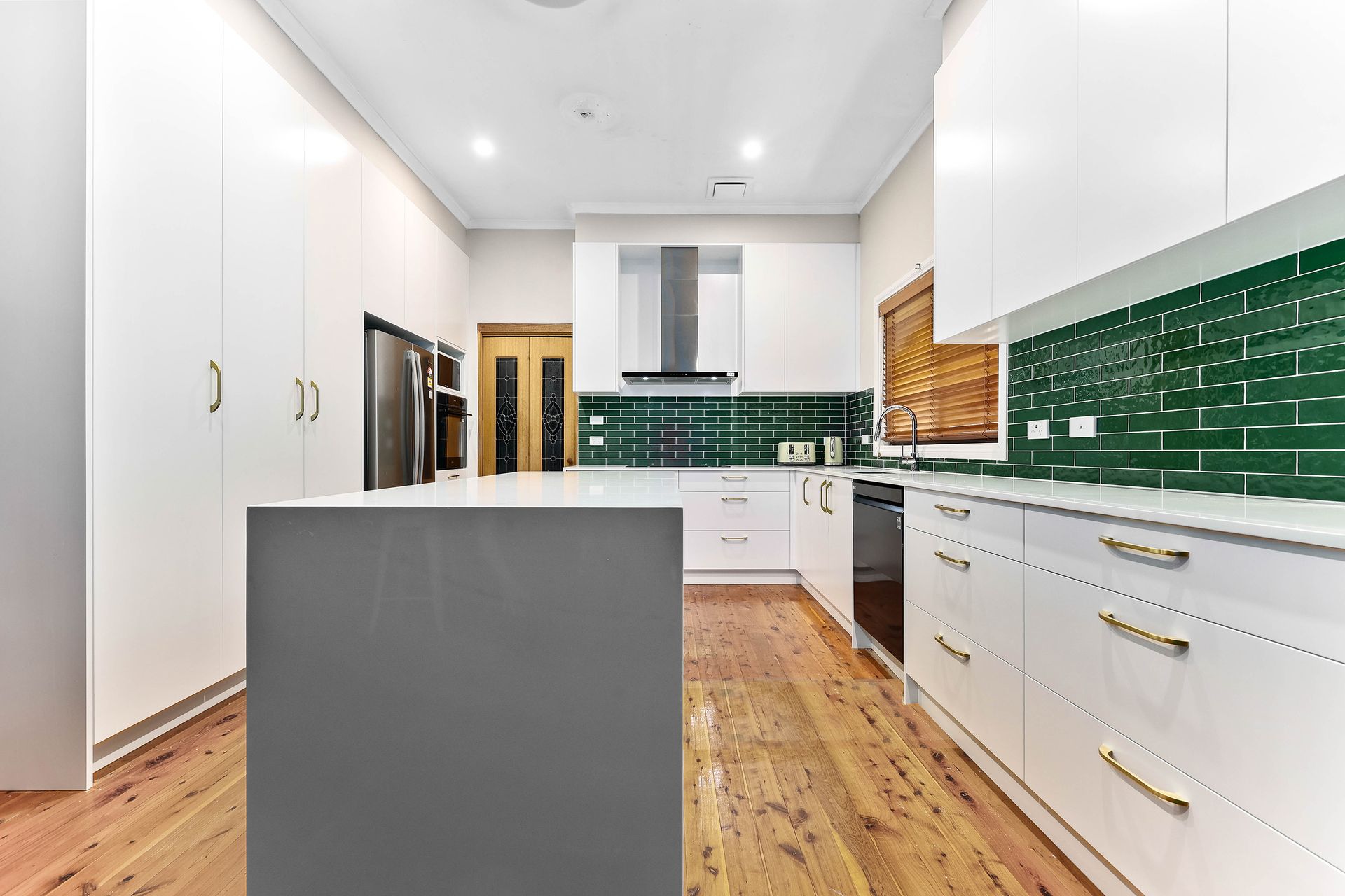 A White Kitchen with Green Tile — Above & Beyond Interiors in Smeaton Grange, NSW