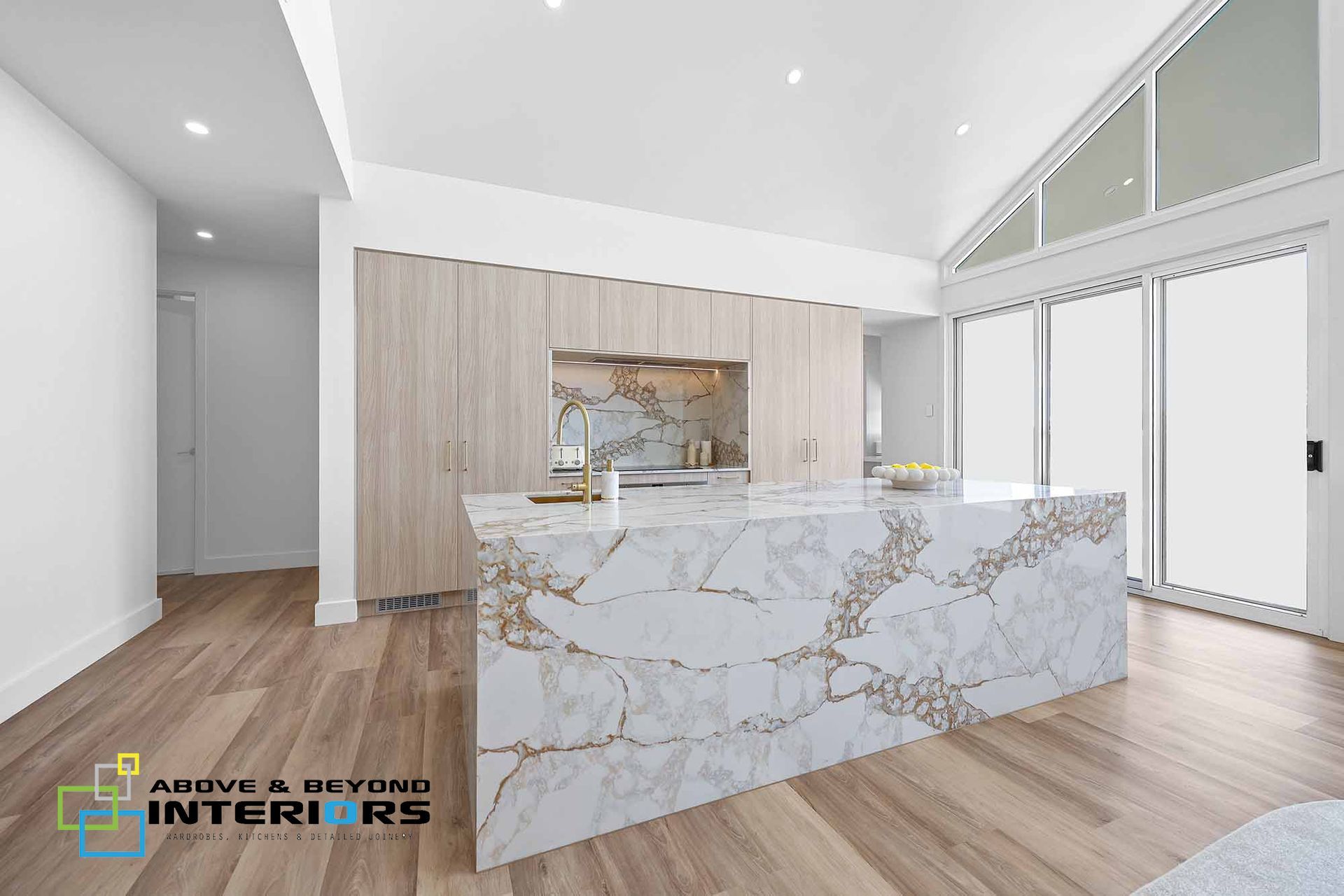Modern White Kitchen with Marble Island and Wood Flooring — Above & Beyond Interiors in Smeaton Grange, NSW