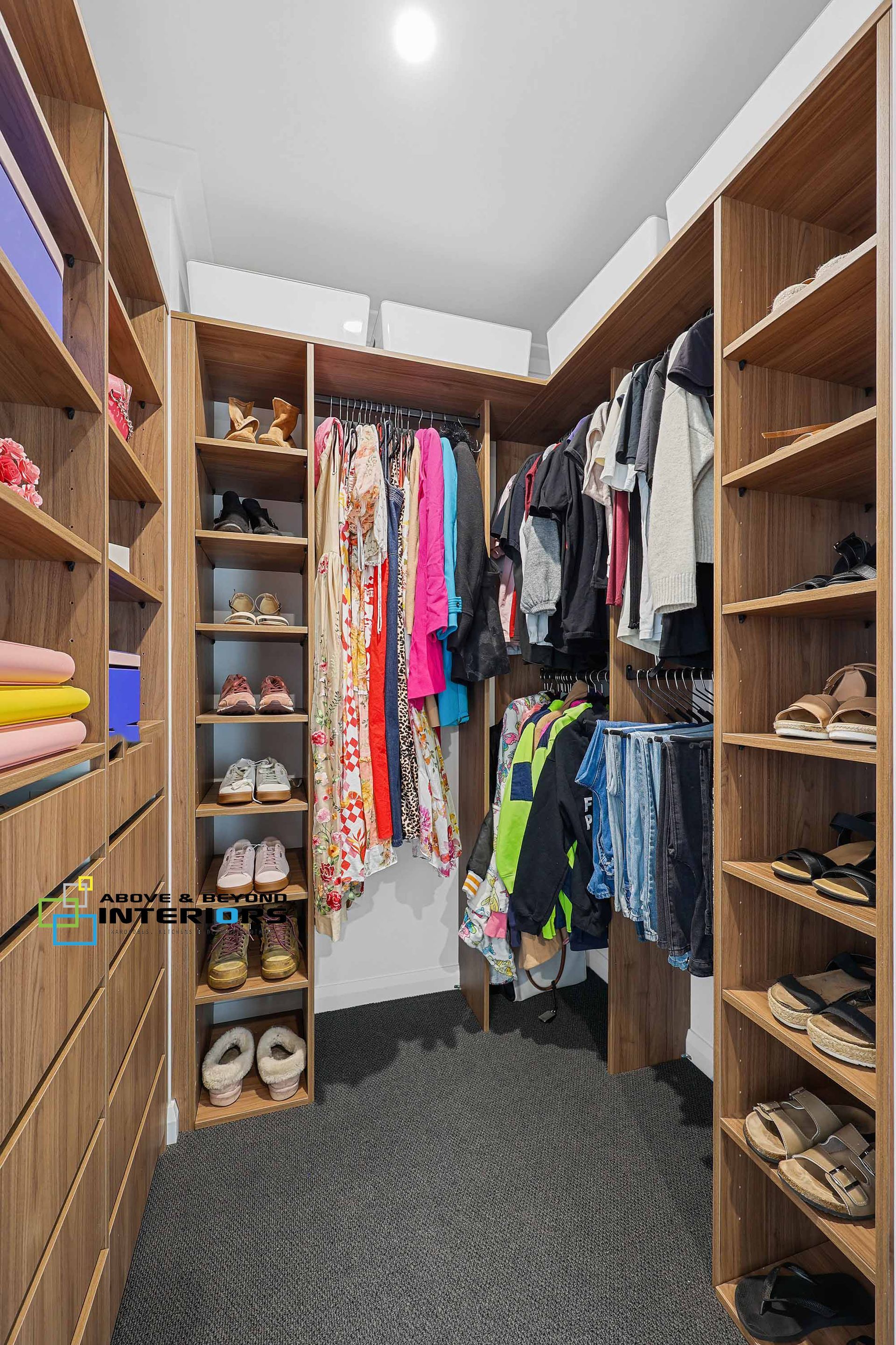 Walk-In Closet with Hanging Clothes — Above & Beyond Interiors in Smeaton Grange, NSW