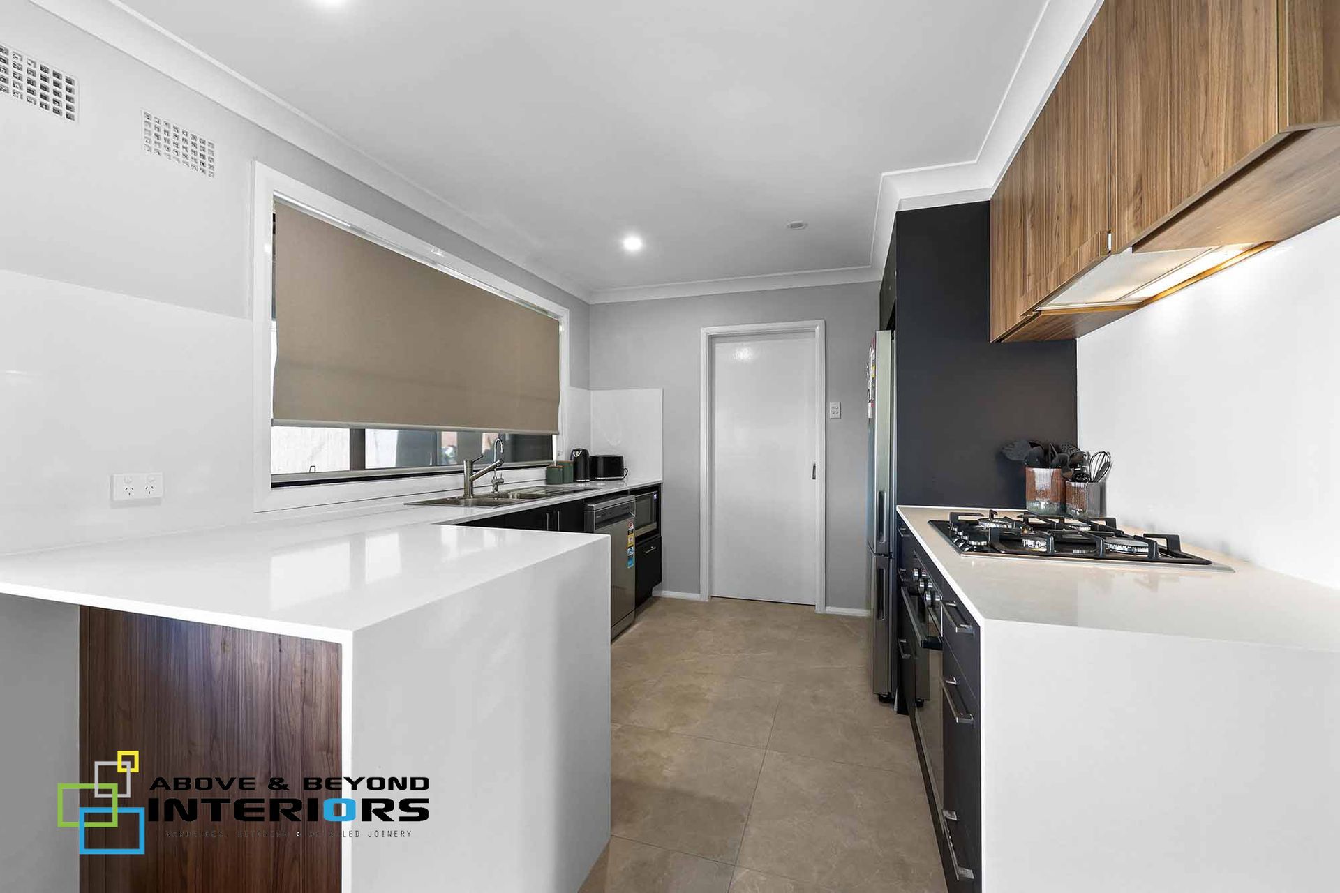 Modern Kitchen with Dark Cabinetry, Wood Upper Cabinets, and Stainless Appliances — Above & Beyond Interiors in Smeaton Grange, NSW