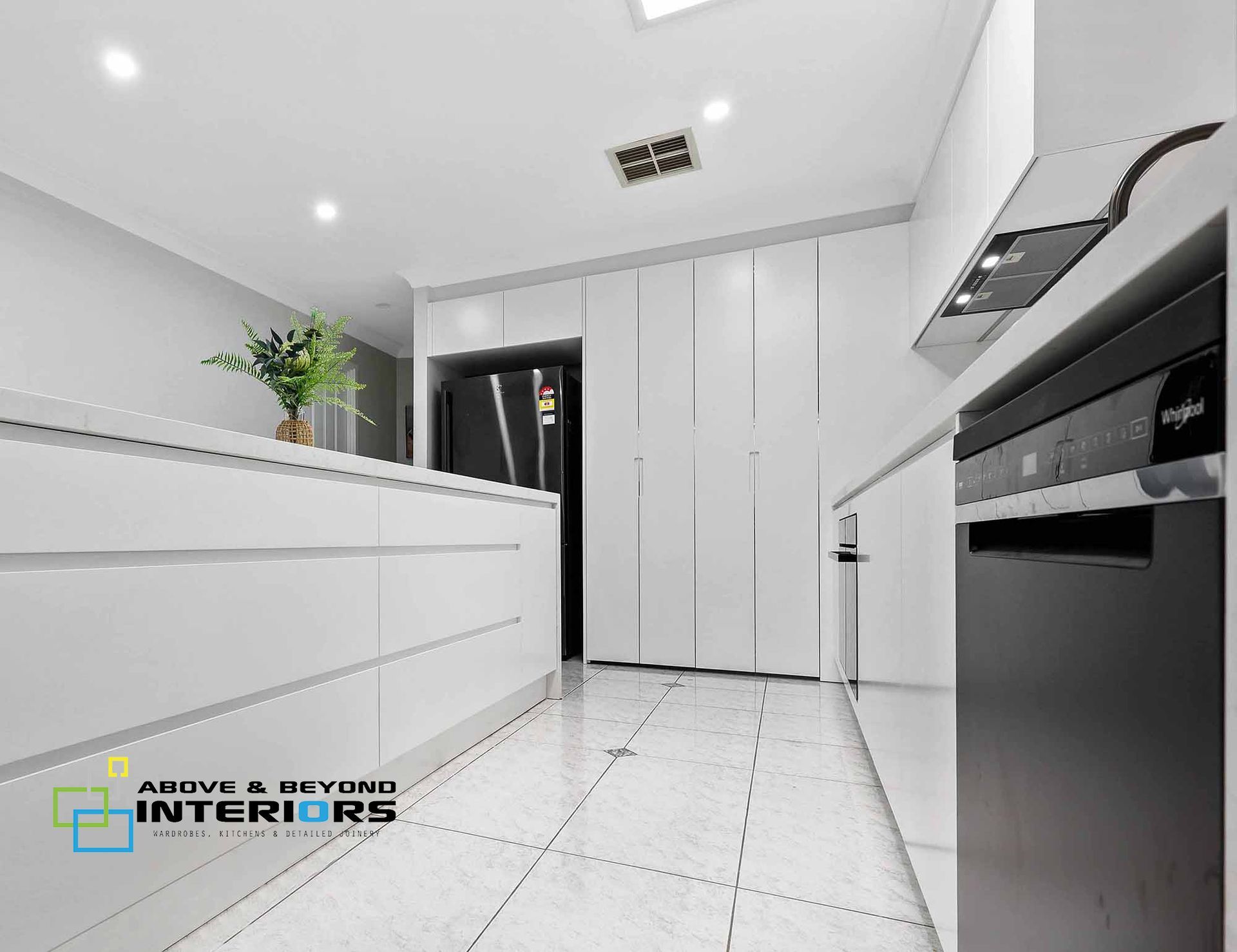 Bright Modern White Kitchen with Glossy Cabinets — Above & Beyond Interiors in Smeaton Grange, NSW
