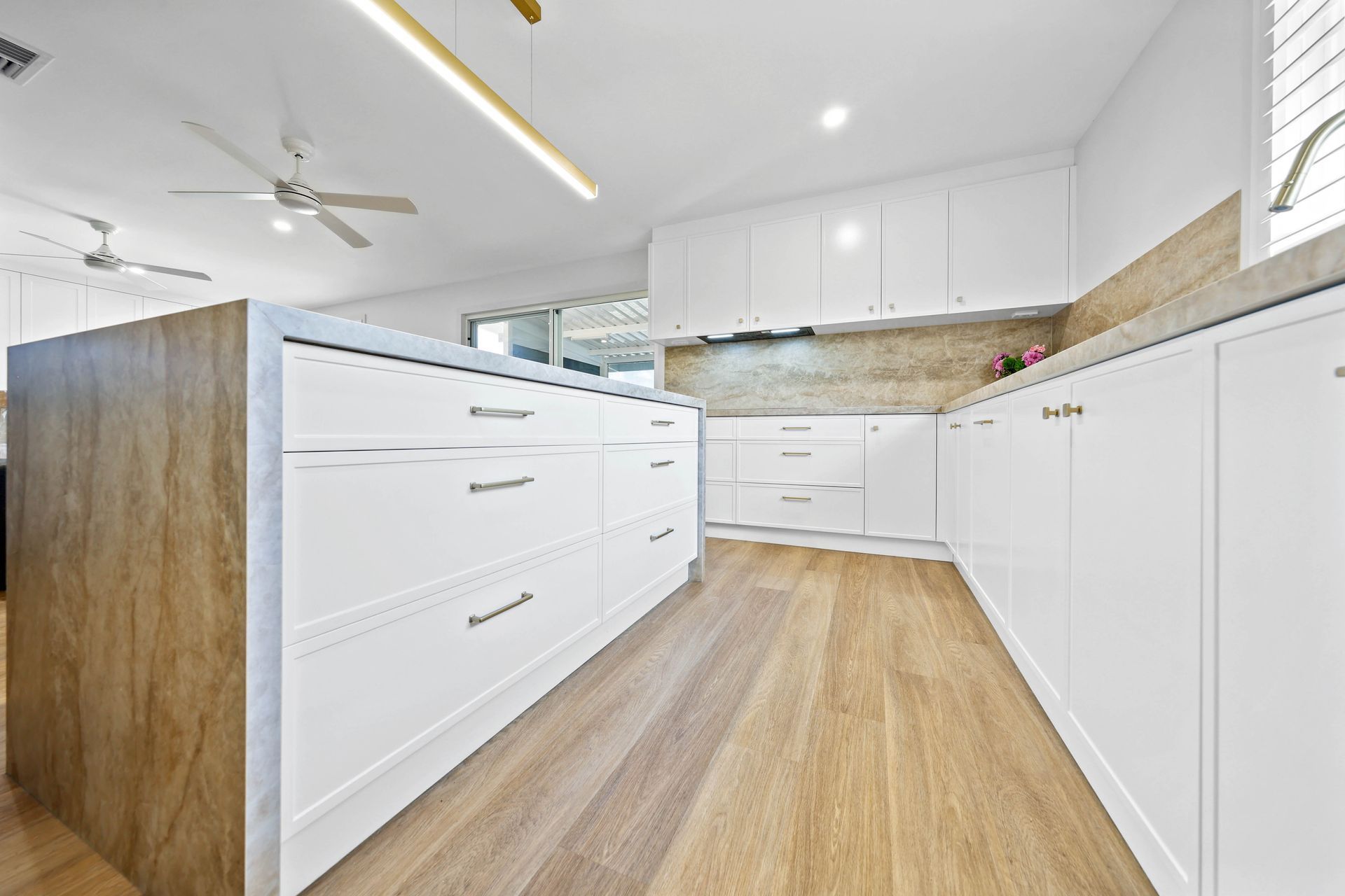 Bright White Kitchen With Wood Floor — Above & Beyond Interiors in Smeaton Grange, NSW