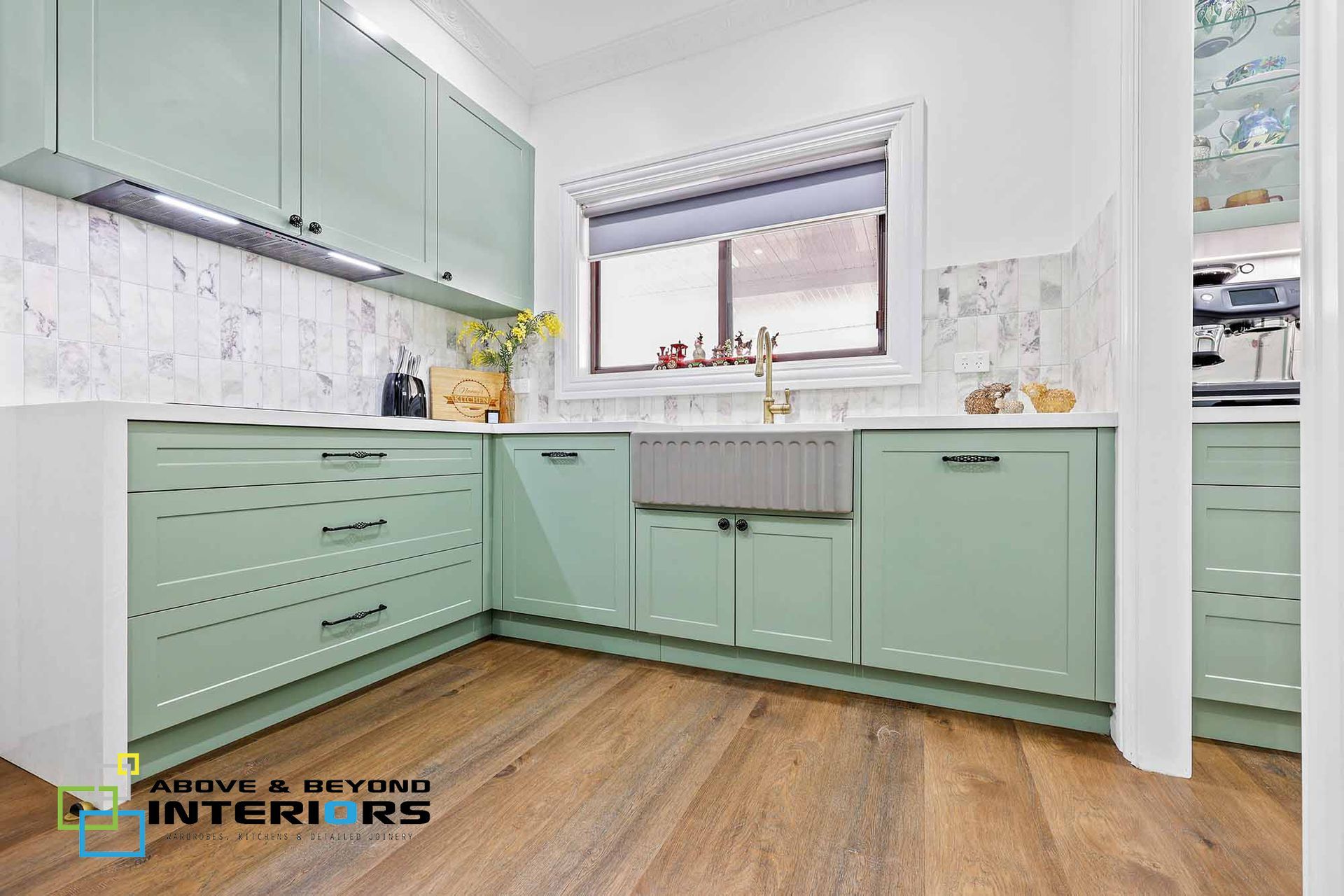A Kitchen with Cabinets, Wooden Floor, and A Window Above the Sink — Above & Beyond Interiors in Smeaton Grange, NSW