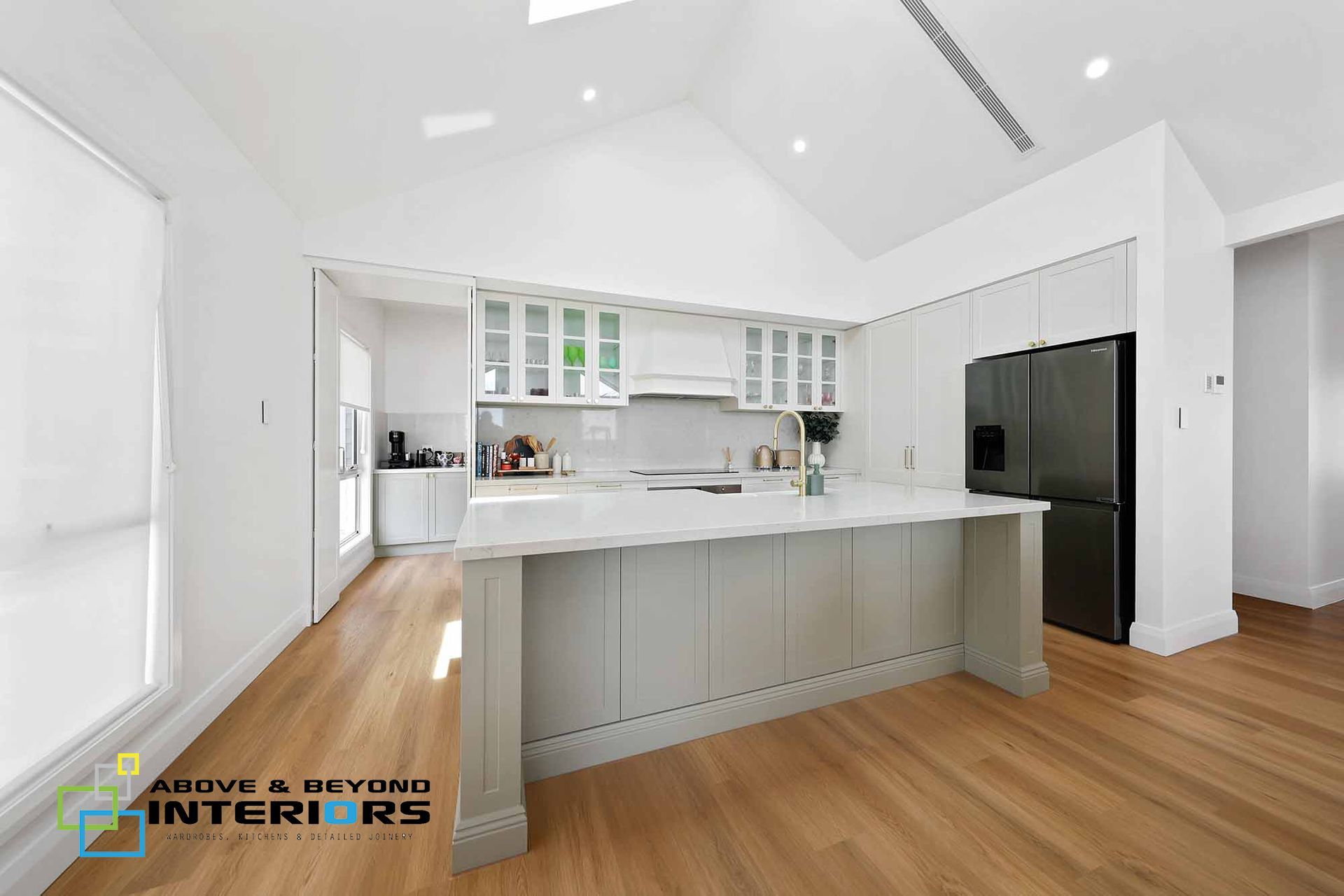 Bright Modern Kitchen with A Wall-Mounted Tv — Above & Beyond Interiors in Smeaton Grange, NSW