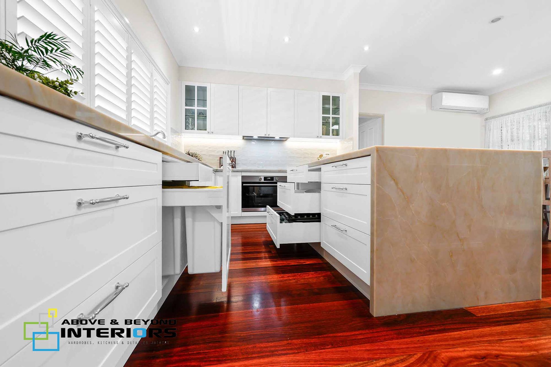 Bright Modern Kitchen with White Cabinets, and Stainless Appliances — Above & Beyond Interiors in Smeaton Grange, NSW