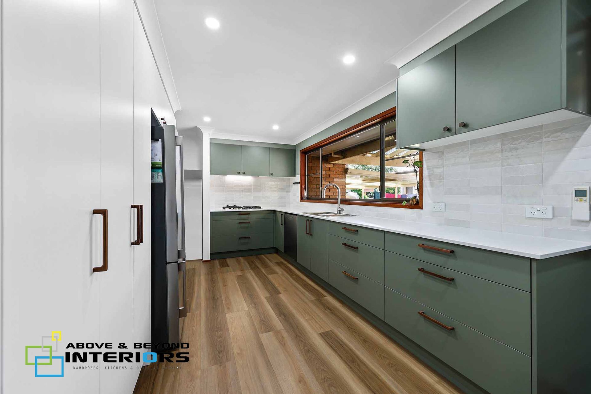 Modern Kitchen with White Countertops, Wood Floors, and A Window Over the Sink — Above & Beyond Interiors in Smeaton Grange, NSW