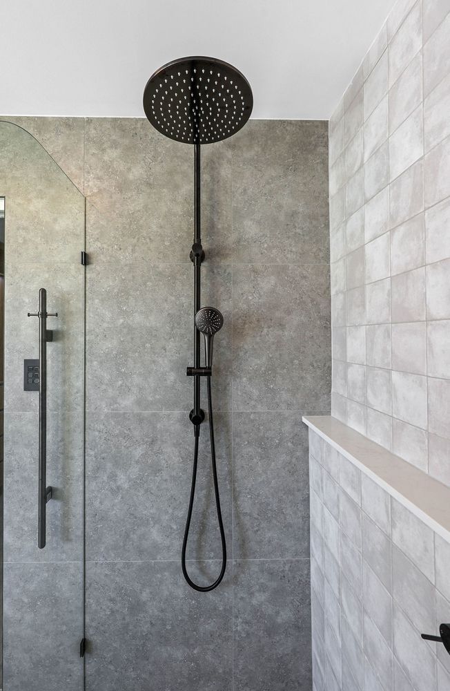 Modern Shower With Black Rainfall Showerhead and Gray Tile Walls — Above & Beyond Interiors in Smeaton Grange, NSW