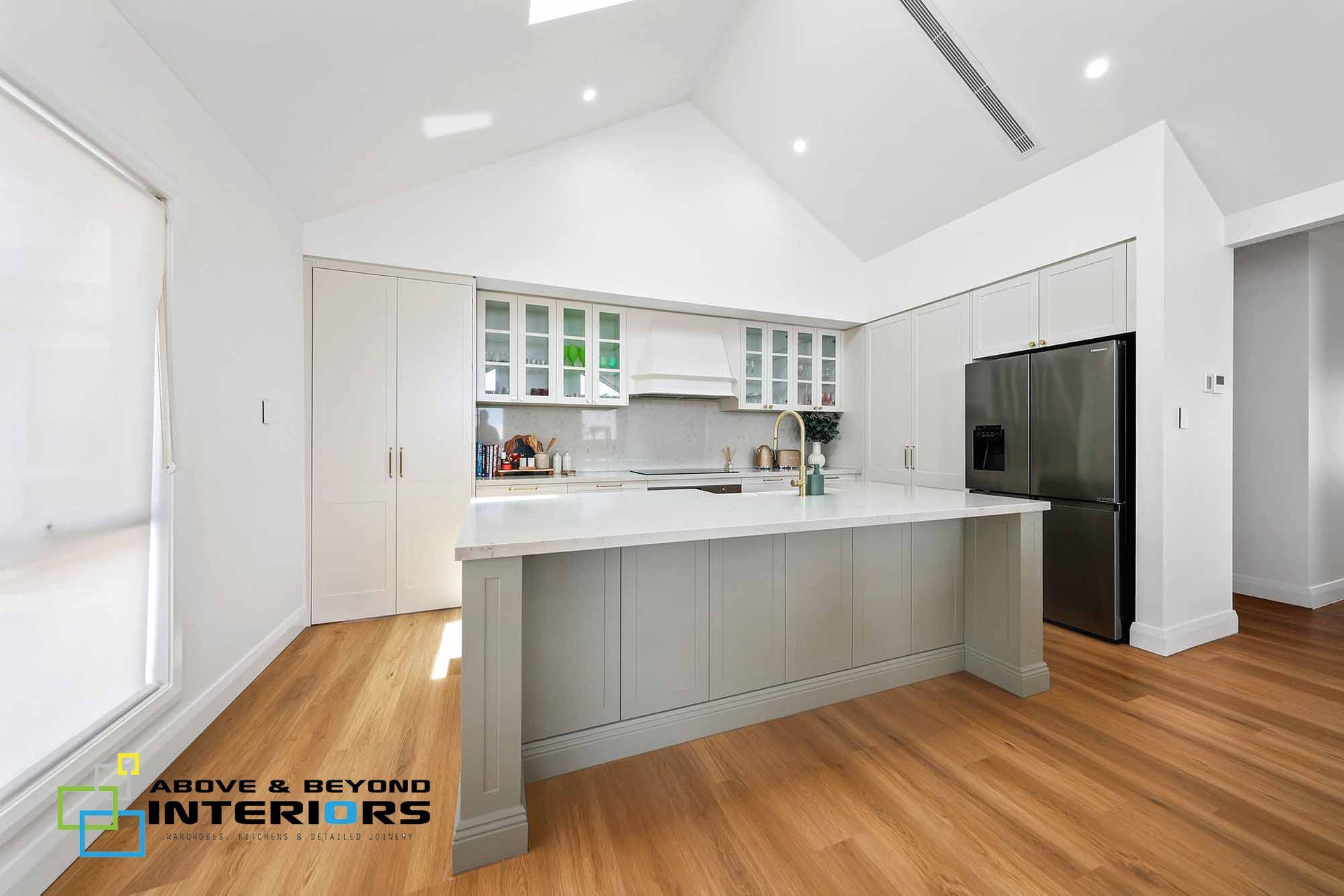Bright Modern Kitchen with Gray Island and Wood Floors — Above & Beyond Interiors in Smeaton Grange, NSW