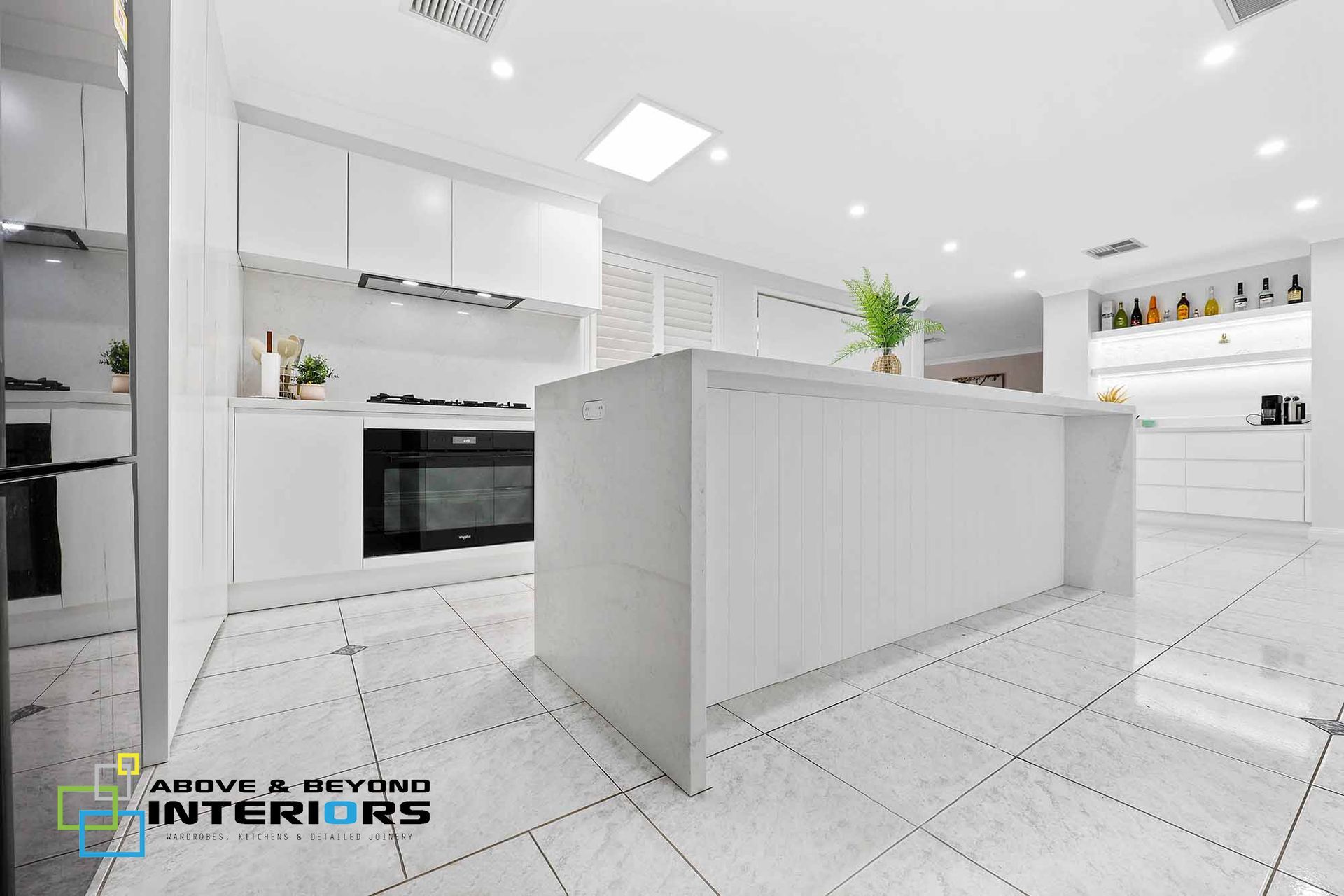 A Modern Kitchen with Island, Tiled Floor, and Built-In Oven — Above & Beyond Interiors in Smeaton Grange, NSW