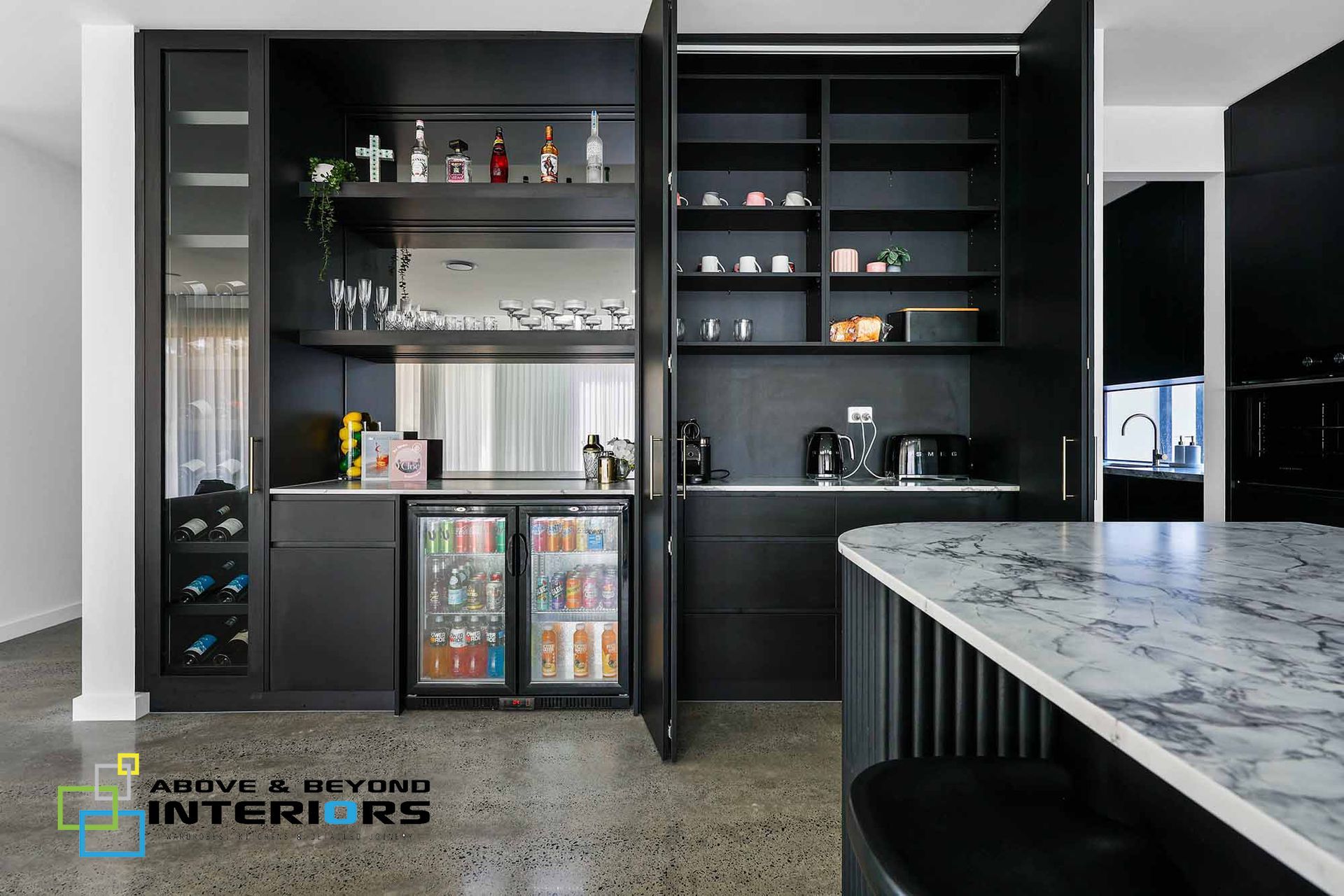 Modern Home Bar with Dark Cabinetry, Glass Shelves, and Marble Countertop — Above & Beyond Interiors in Smeaton Grange, NSW
