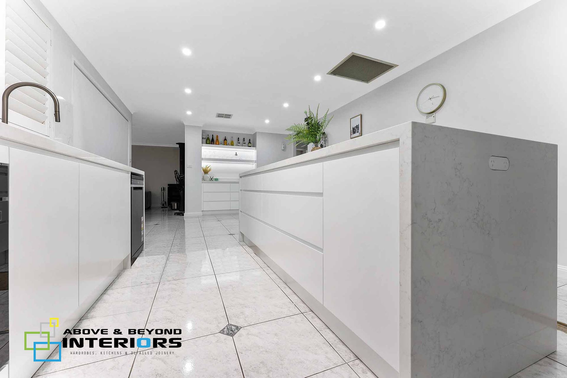 Modern White Kitchen with Glossy Cabinets — Above & Beyond Interiors in Smeaton Grange, NSW