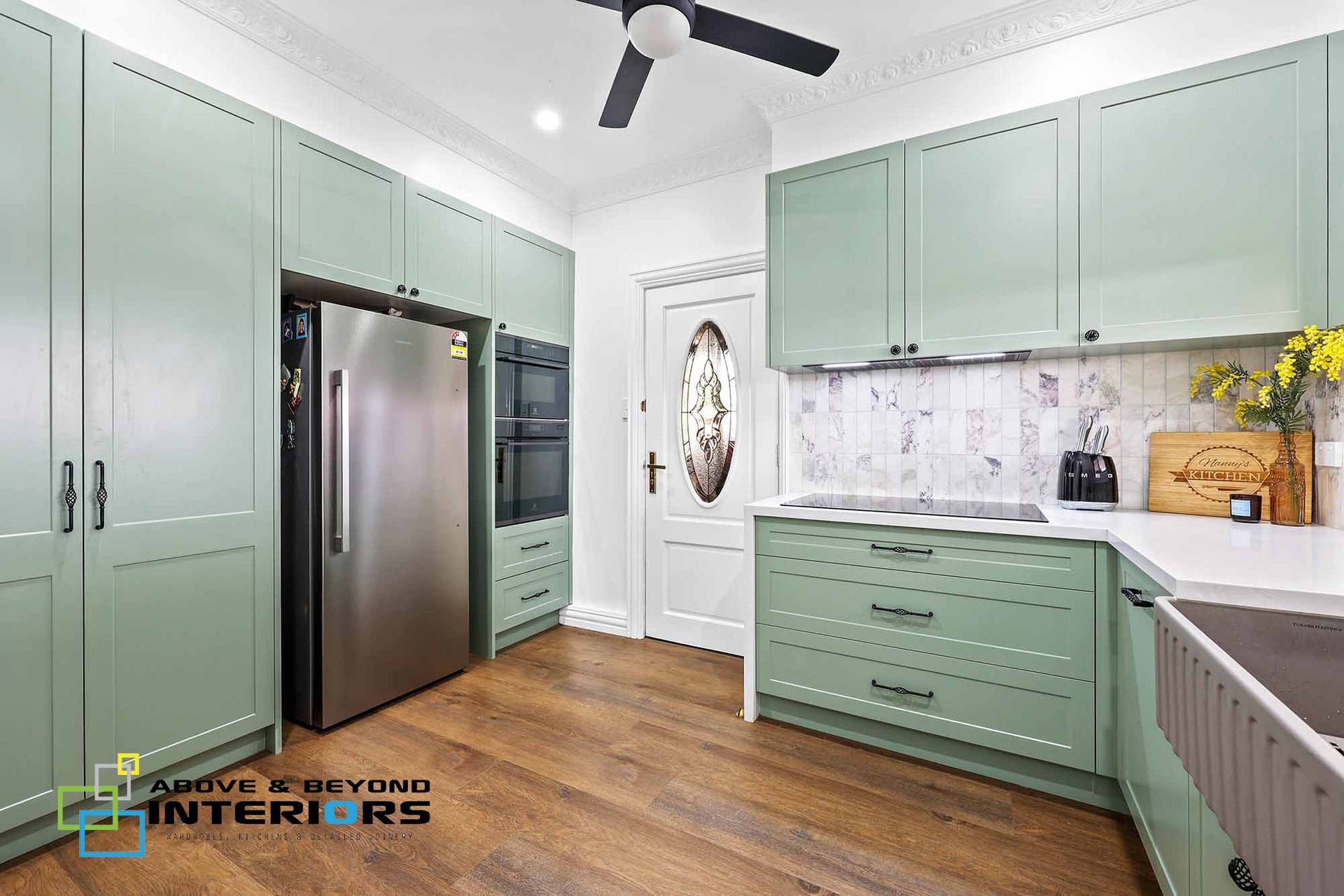 Mint-Green Kitchen with Stainless Steel Fridge, Wood Floors, and White Marble Backsplash — Above & Beyond Interiors in Smeaton Grange, NSW