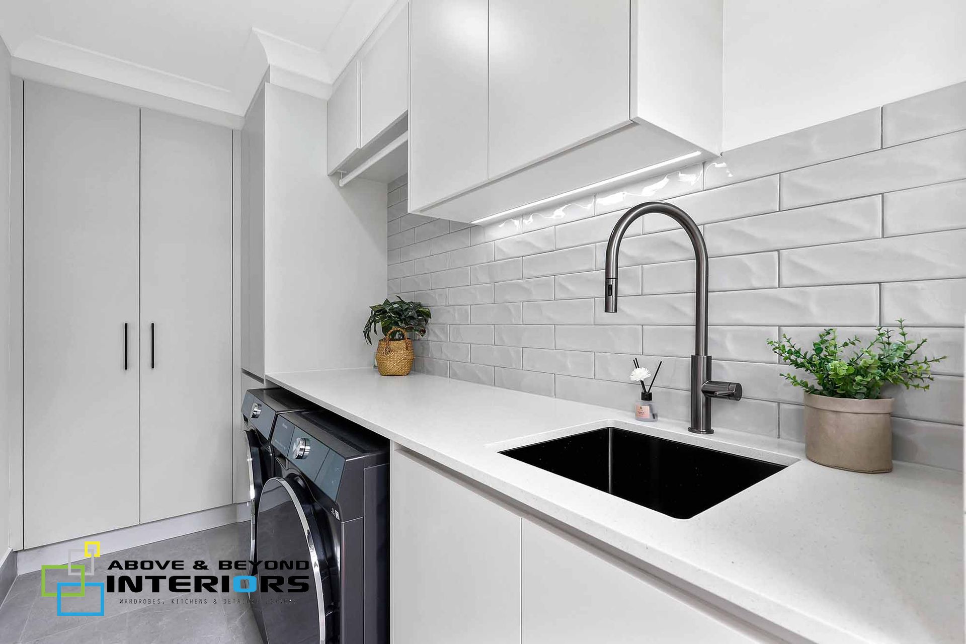 Bright White Laundry Room with Stacked Washer-Dryer — Above & Beyond Interiors in Smeaton Grange, NSW