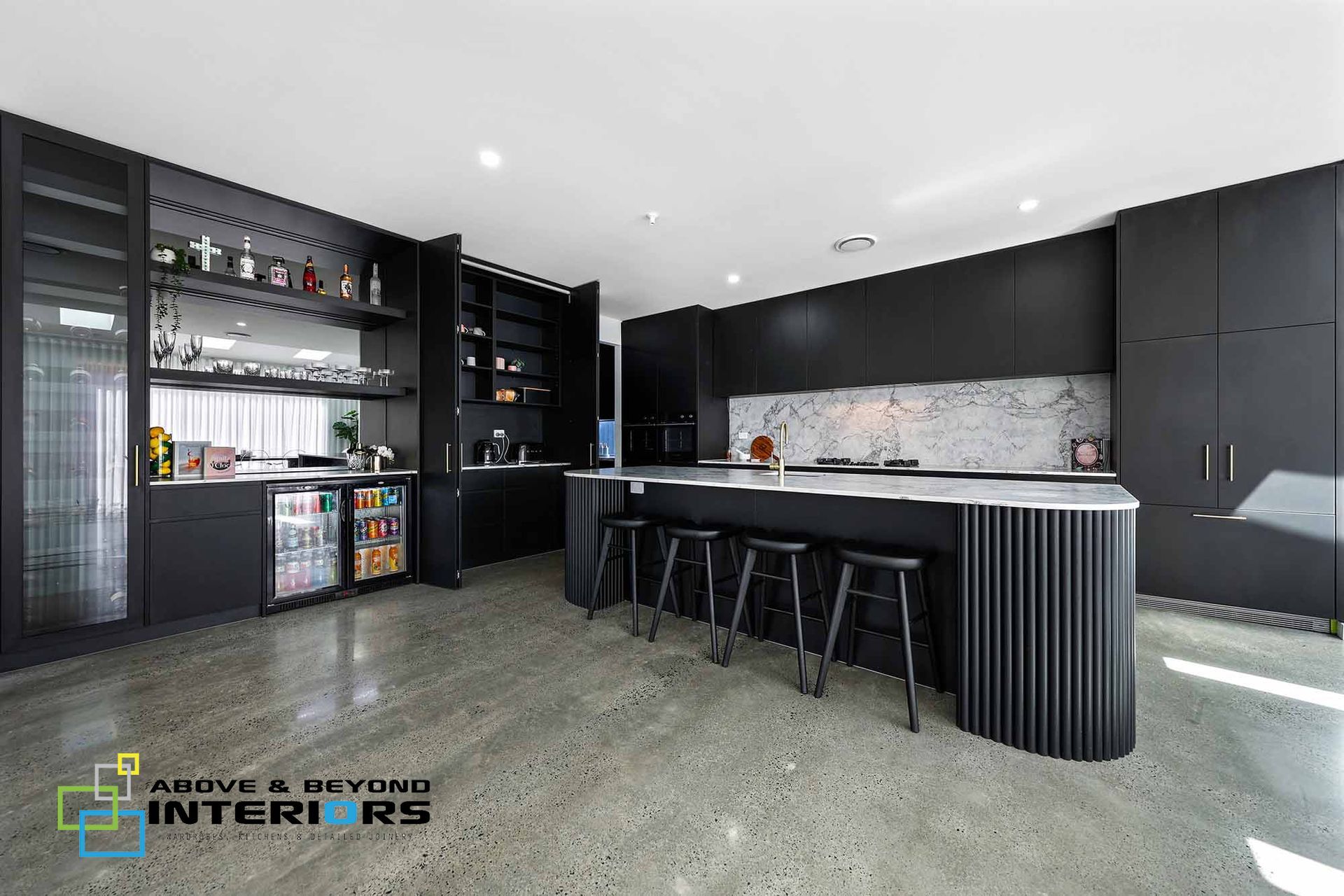 Modern Black Kitchen with Island, and Speckled Stone Floor — Above & Beyond Interiors in Smeaton Grange, NSW