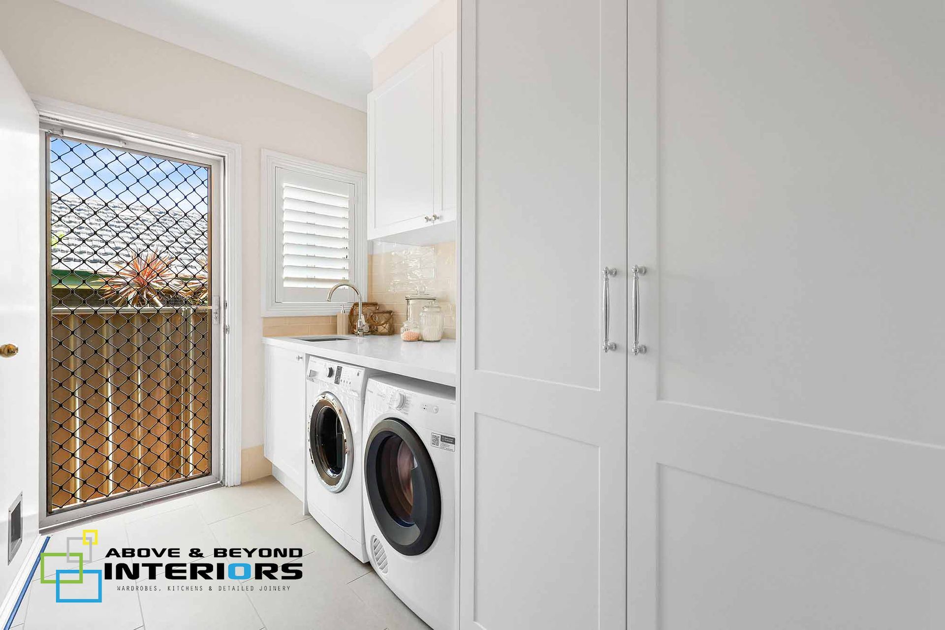 Bright Laundry Room with Front-Load Washer and Dryer — Above & Beyond Interiors in Smeaton Grange, NSW