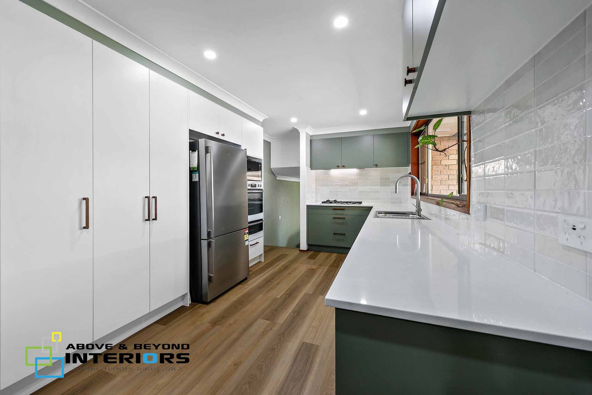 Modern White Kitchen with Stainless Steel Fridge — Above & Beyond Interiors in Smeaton Grange, NSW