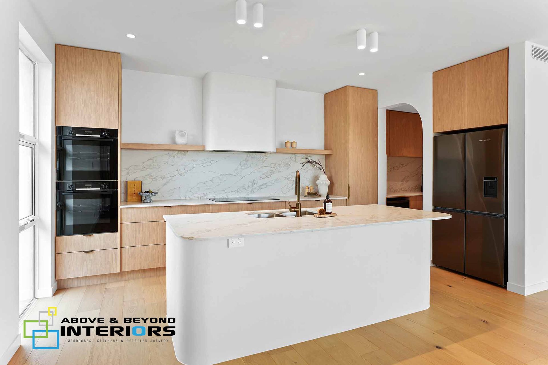 Modern White Kitchen with Wood Cabinets — Above & Beyond Interiors in Smeaton Grange, NSW