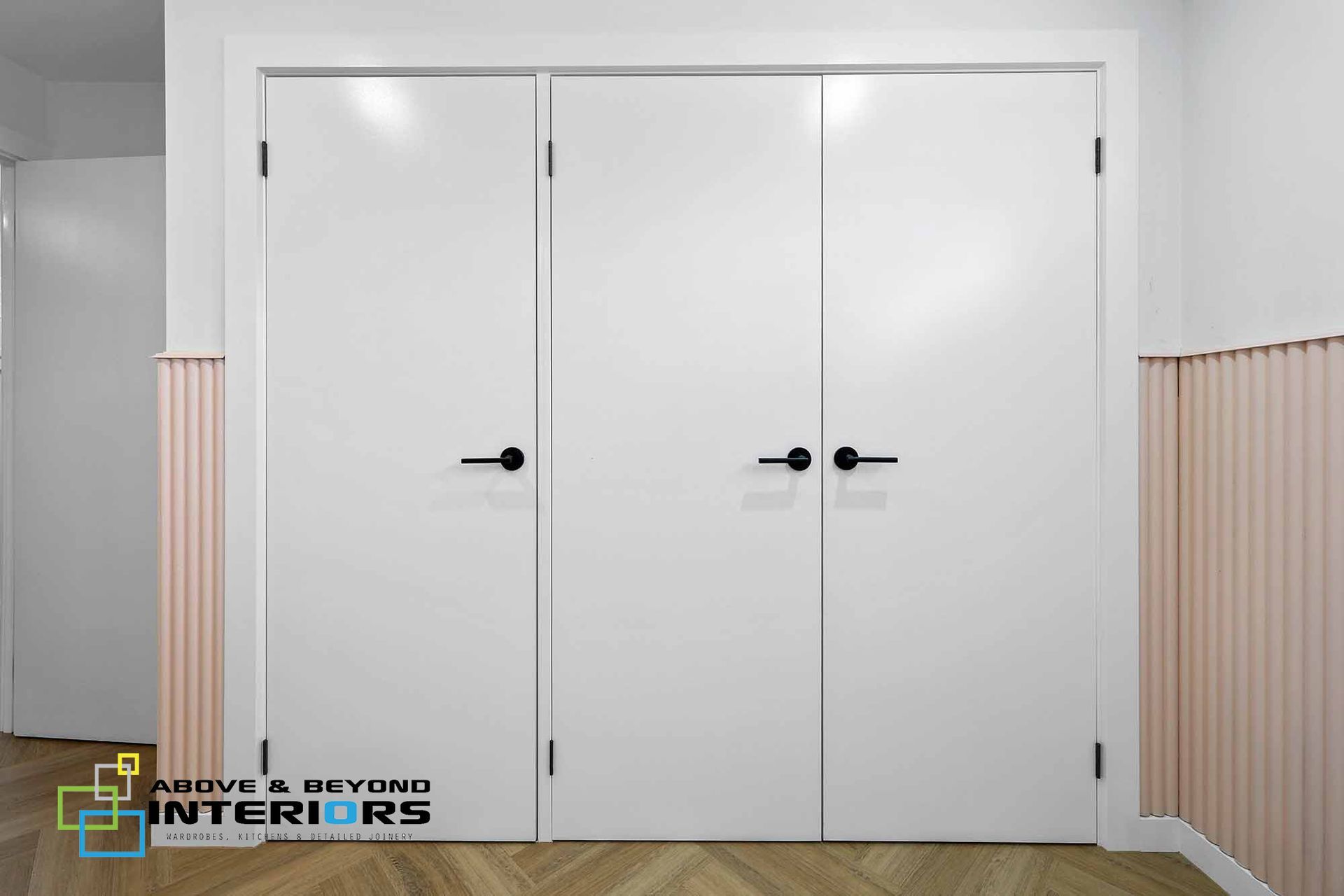 White Double Interior Doors with Black Handles in A Light Room — Above & Beyond Interiors in Smeaton Grange, NSW