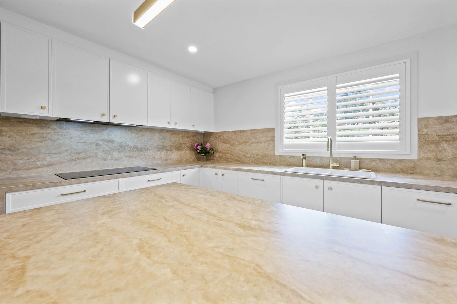 Bright White Kitchen With Marble Countertops — Above & Beyond Interiors in Smeaton Grange, NSW