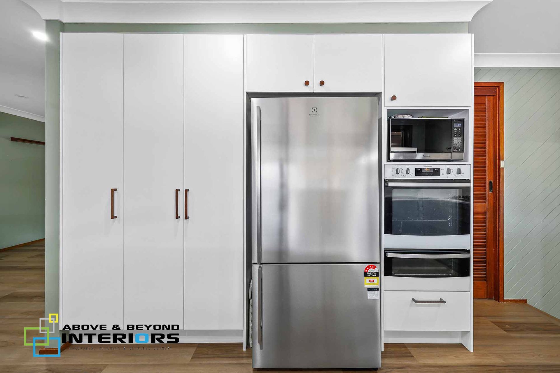White Built-In Kitchen Cabinets with Stainless Refrigerator — Above & Beyond Interiors in Smeaton Grange, NSW