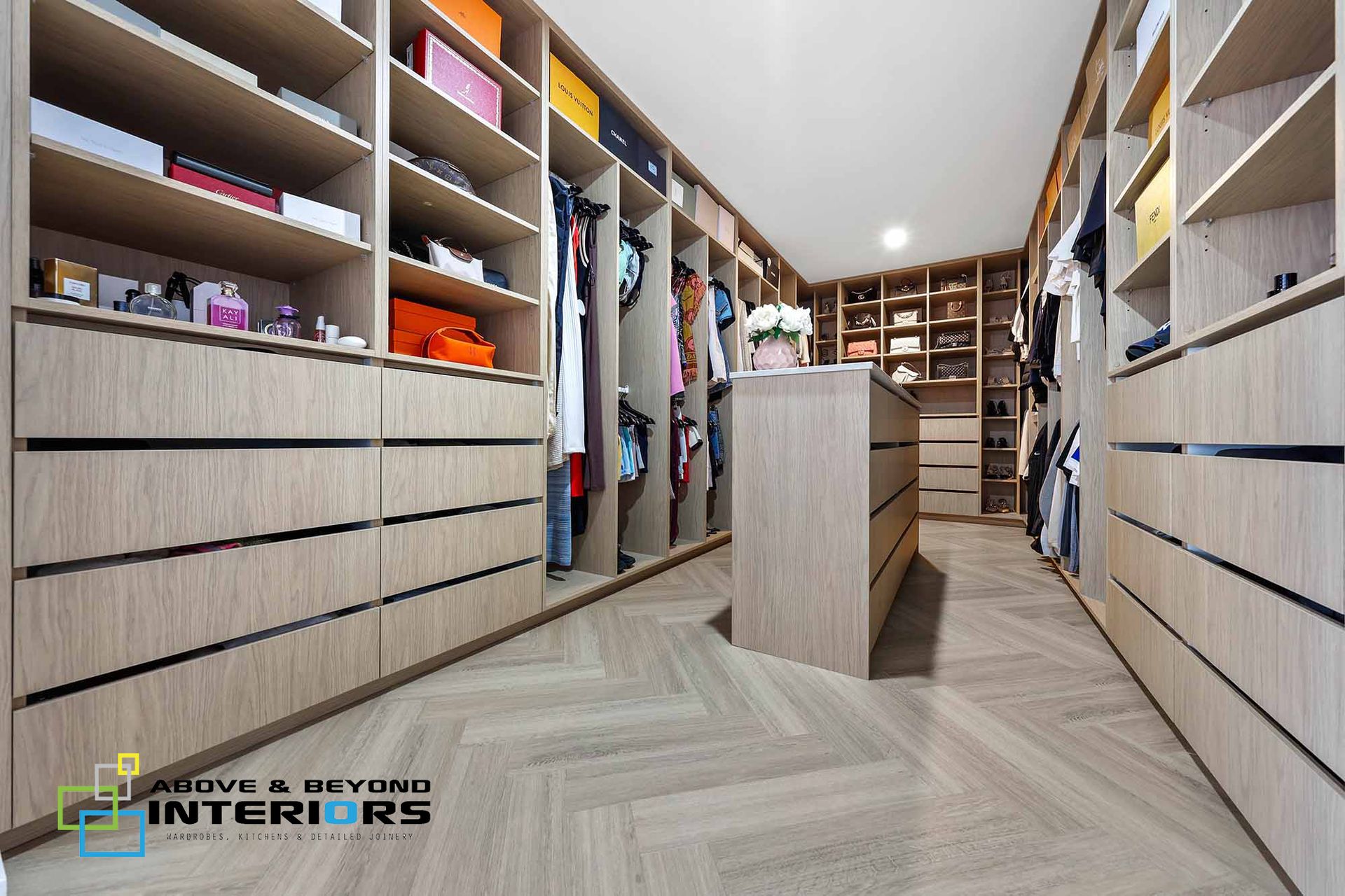 Modern Walk-In Closet with Built-In Shelves, Drawers, and A Central Island — Above & Beyond Interiors in Smeaton Grange, NSW
