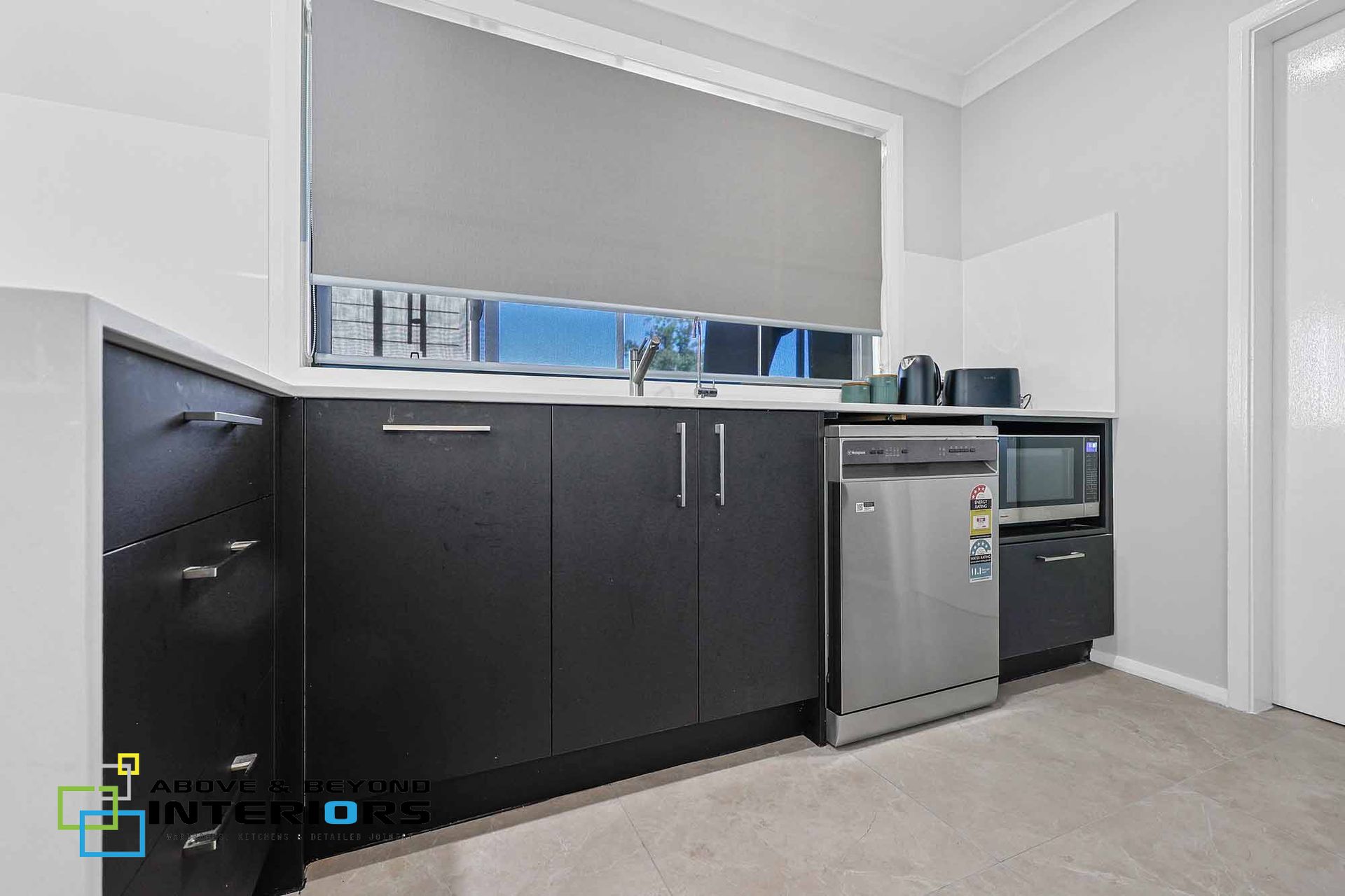 A Kitchen with Black Cabinets — Above & Beyond Interiors in Smeaton Grange, NSW
