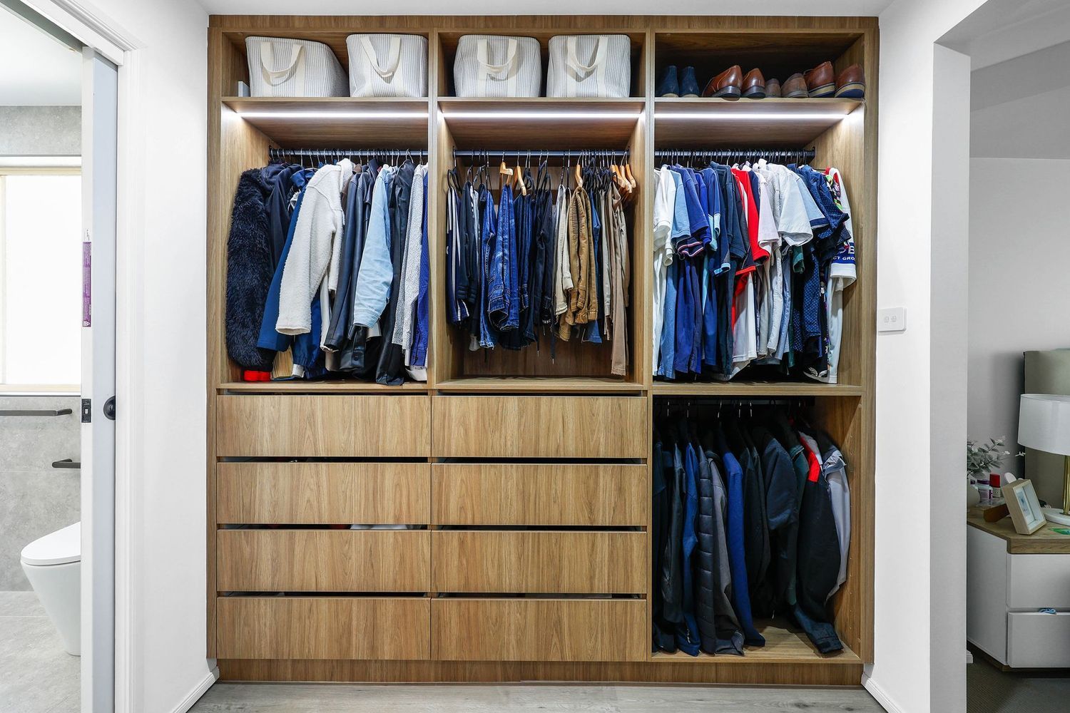 Built-in Wooden Closet With Hanging Clothes and Drawers in a Bedroom — Above & Beyond Interiors in Smeaton Grange, NSW