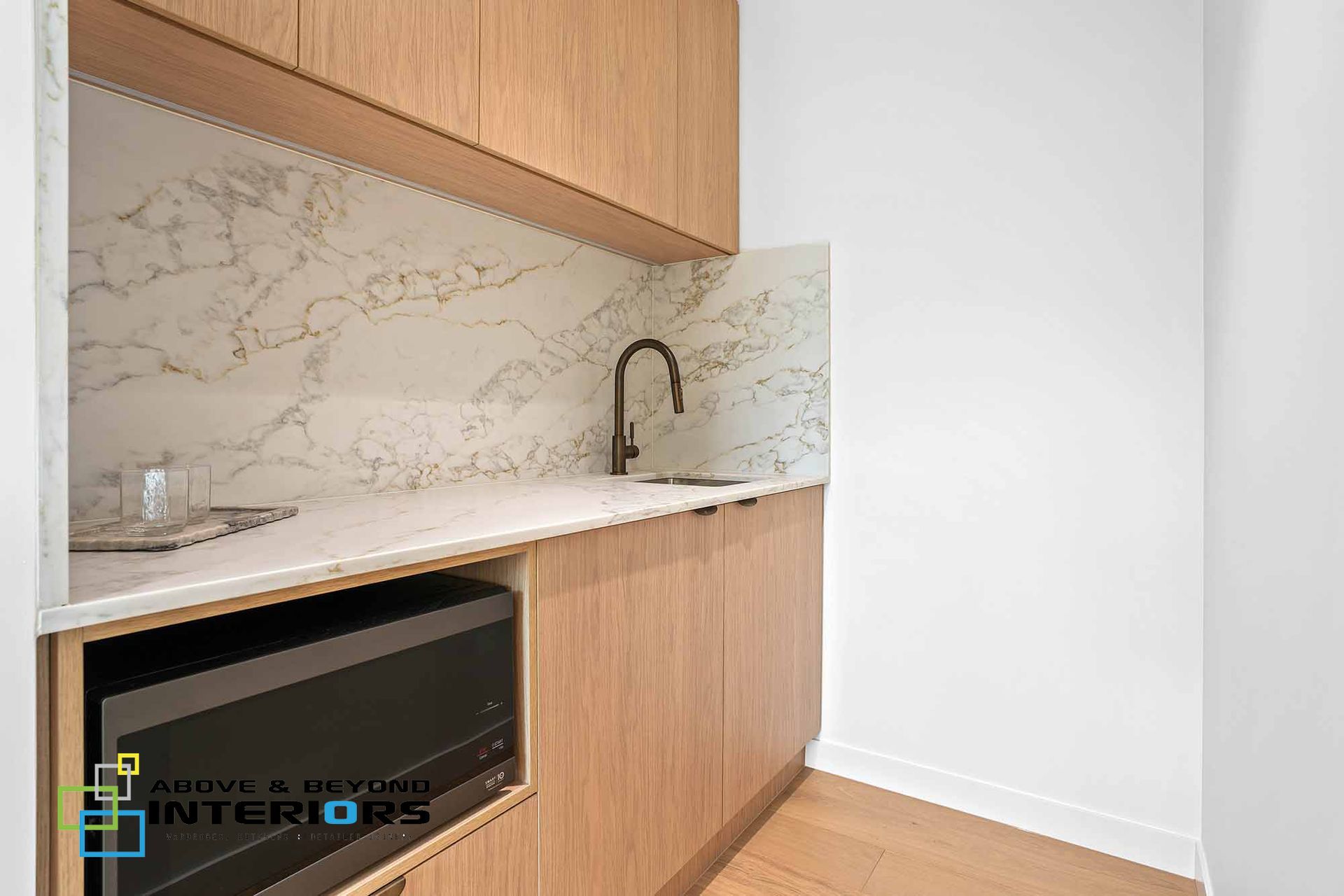 Modern Kitchenette with Marble Backsplash, Sink, and Built-In Microwave — Above & Beyond Interiors in Smeaton Grange, NSW