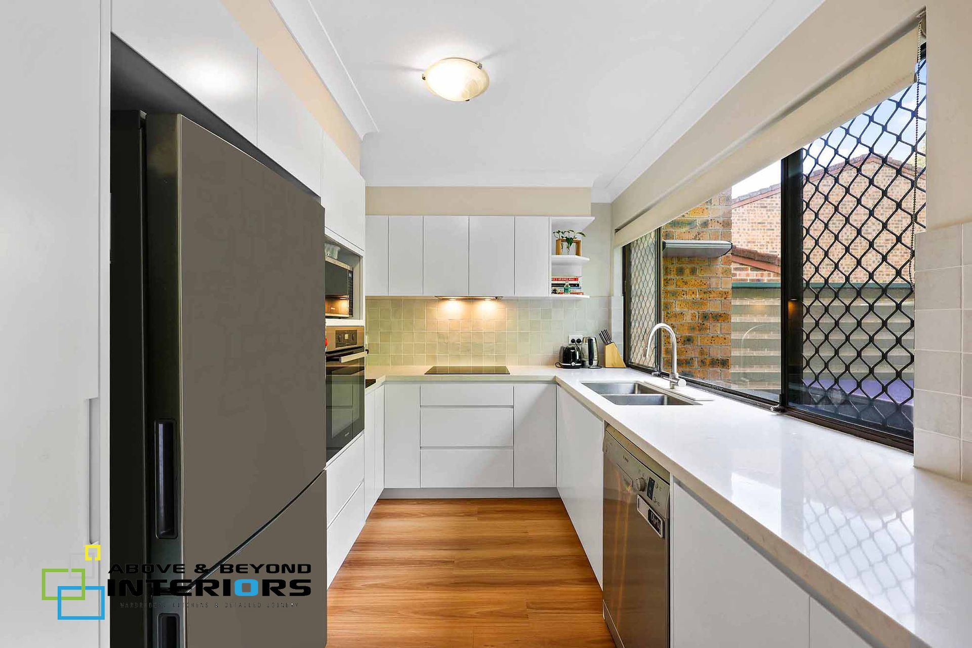 Narrow Modern Kitchen with White Cabinets — Above & Beyond Interiors in Smeaton Grange, NSW