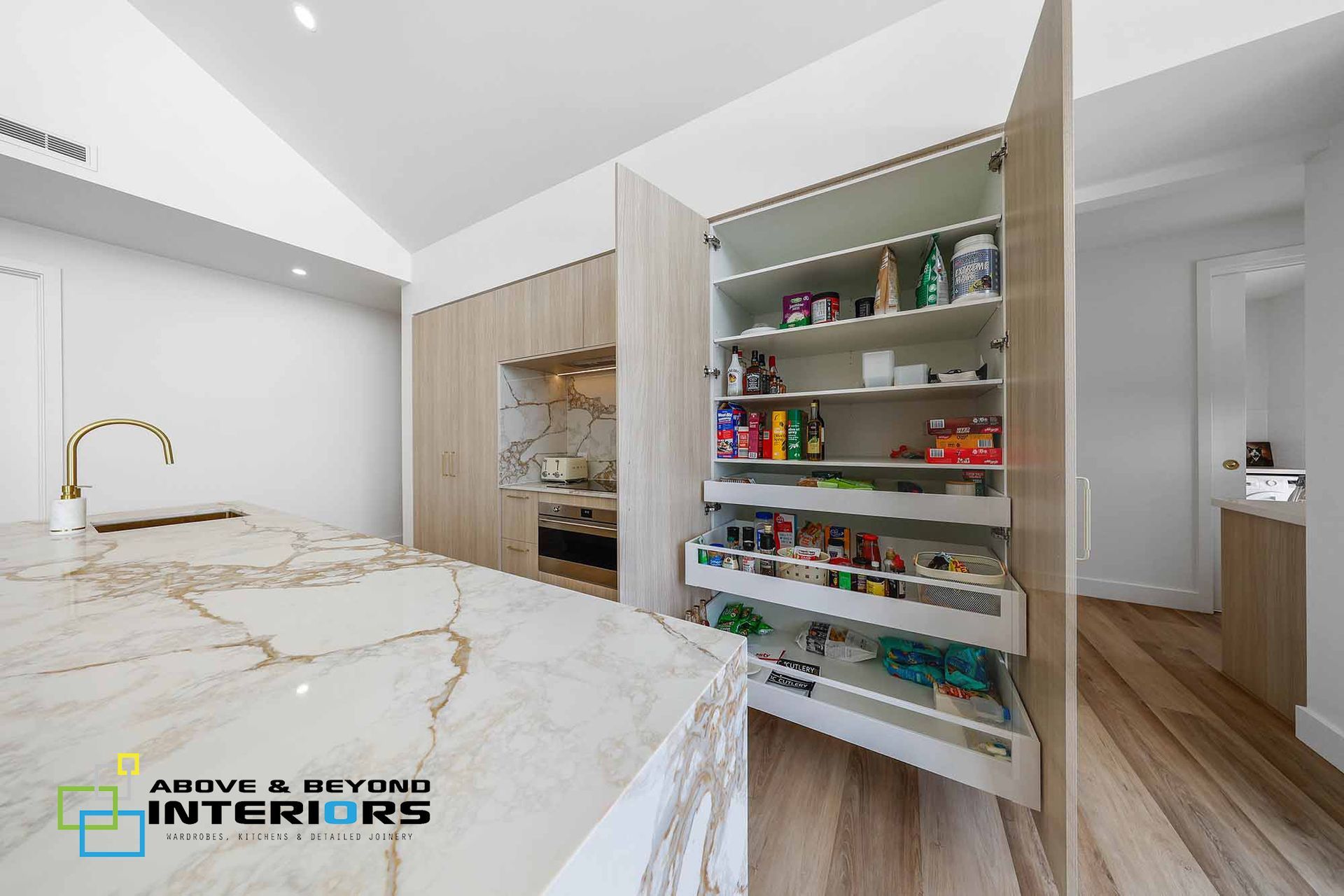 Modern White Kitchen with Marble Island and Open Pantry Cabinet — Above & Beyond Interiors in Smeaton Grange, NSW