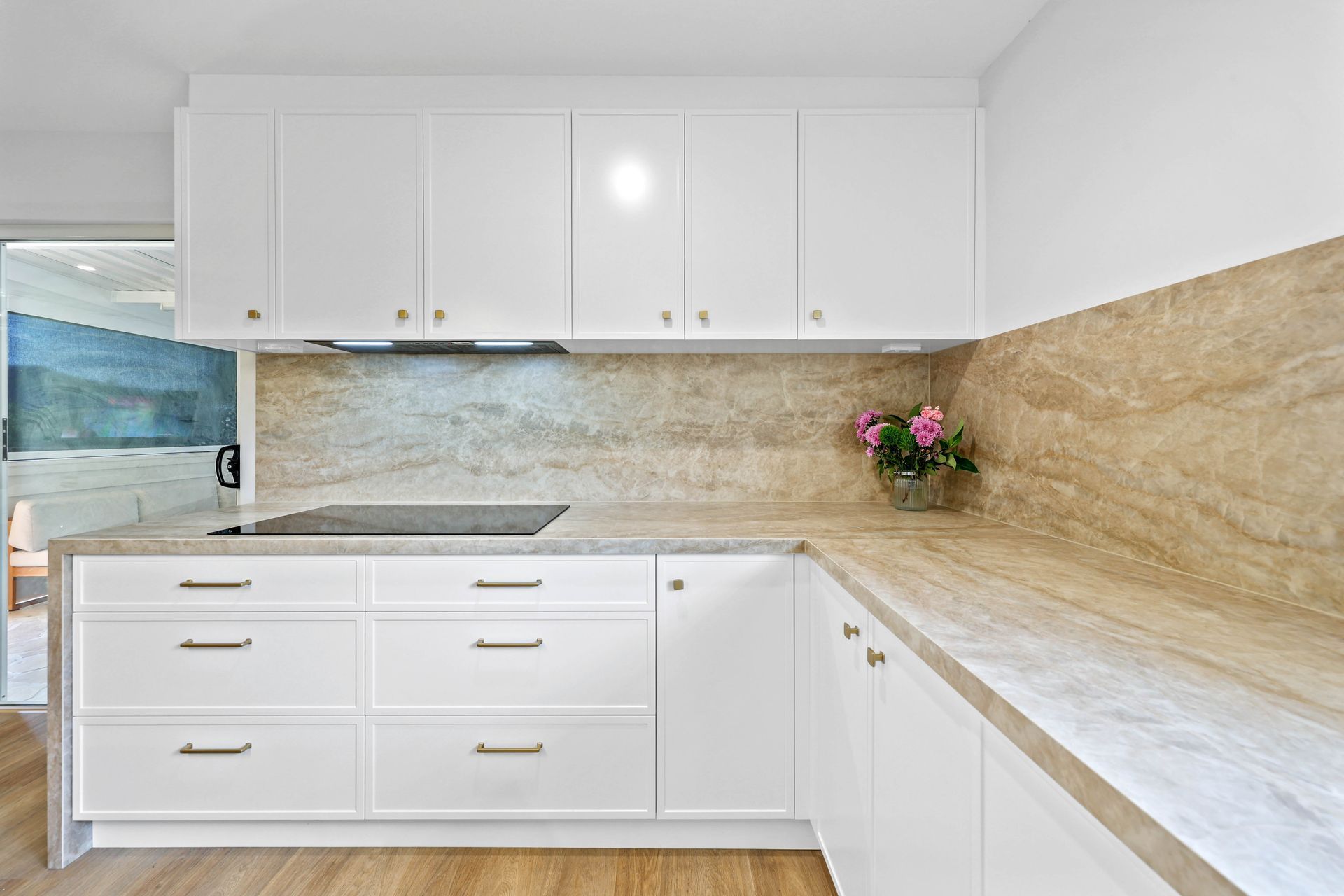 Bright White Kitchen With Beige Stone Backsplash — Above & Beyond Interiors in Smeaton Grange, NSW