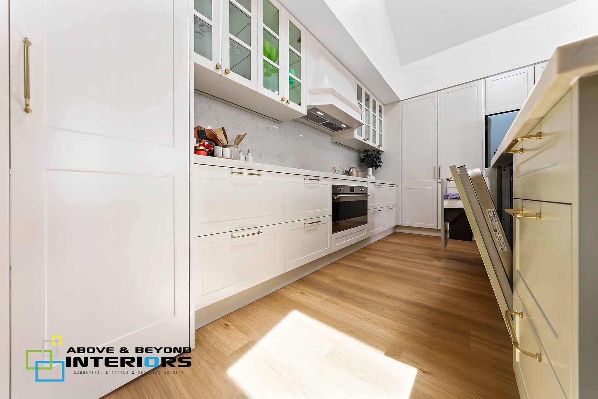 Bright Modern Kitchen with Wooden Floor, and Built-In Appliances — Above & Beyond Interiors in Smeaton Grange, NSW