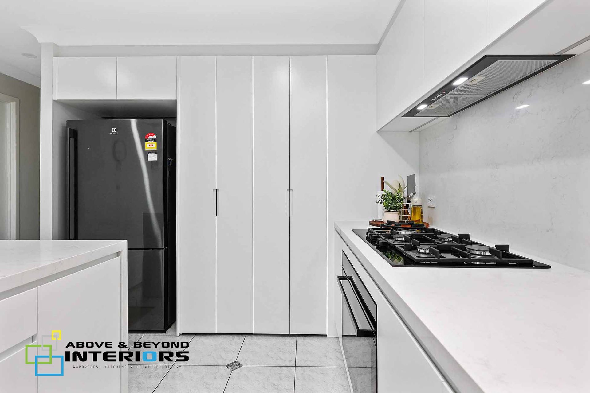 Modern White Kitchen with Black Refrigerator — Above & Beyond Interiors in Smeaton Grange, NSW