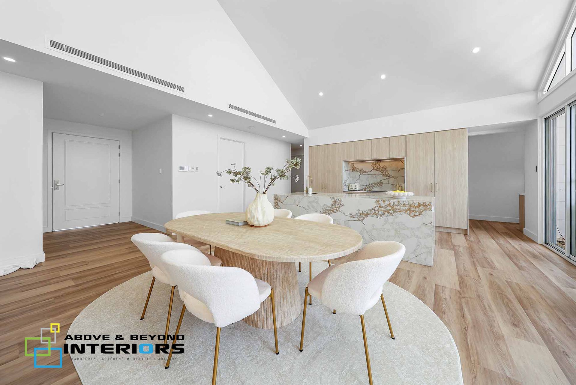 Modern Open Dining Room with A Round Wood Table — Above & Beyond Interiors in Smeaton Grange, NSW