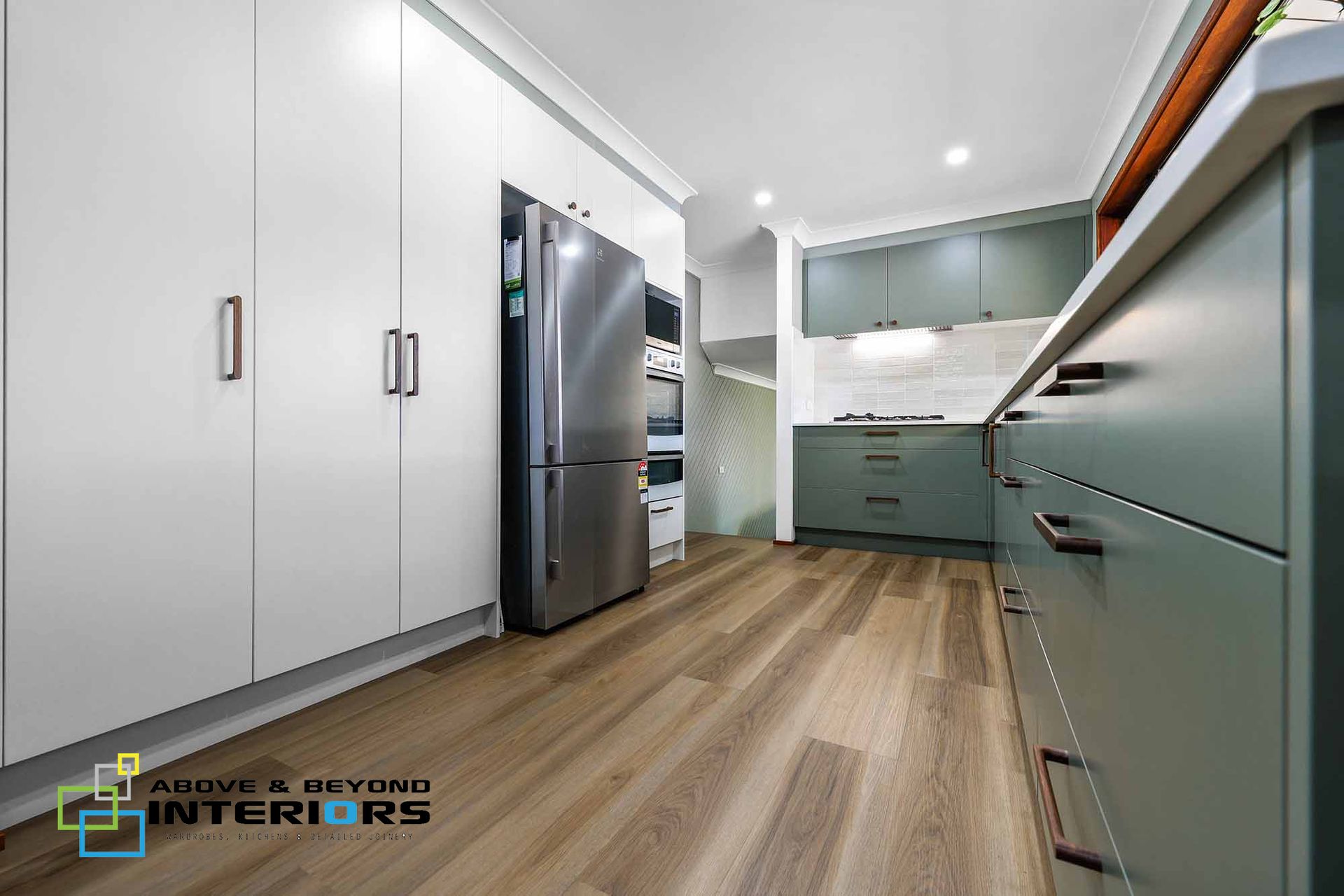 Modern Kitchen with White Cabinets, and Stainless Steel Fridge — Above & Beyond Interiors in Smeaton Grange, NSW