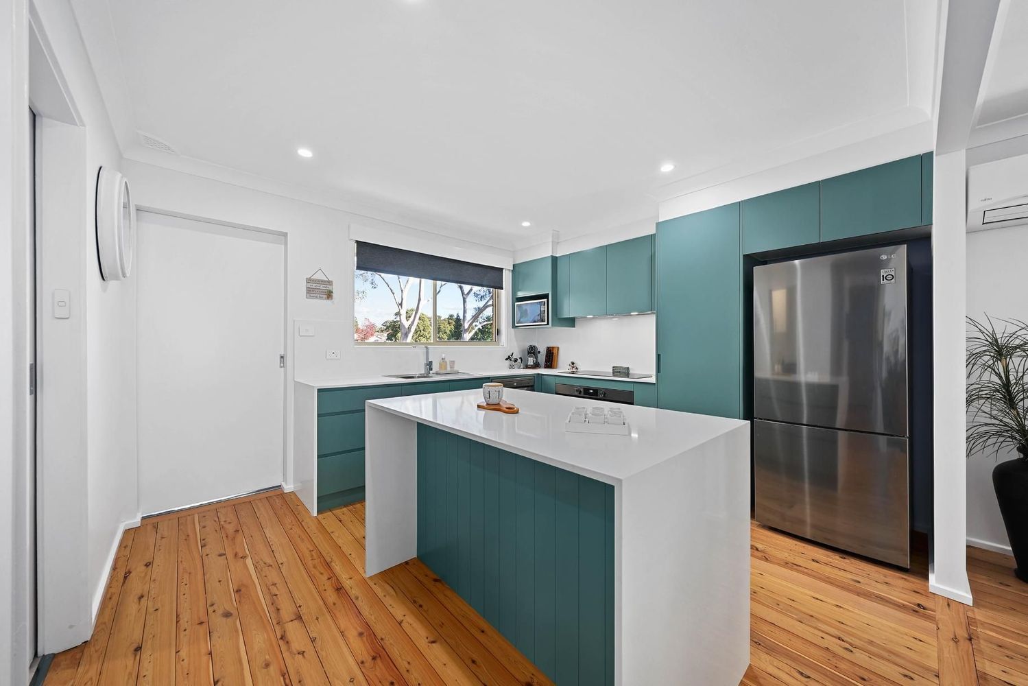 Bright Modern Kitchen With Teal Cabinets — Above & Beyond Interiors in Smeaton Grange, NSW