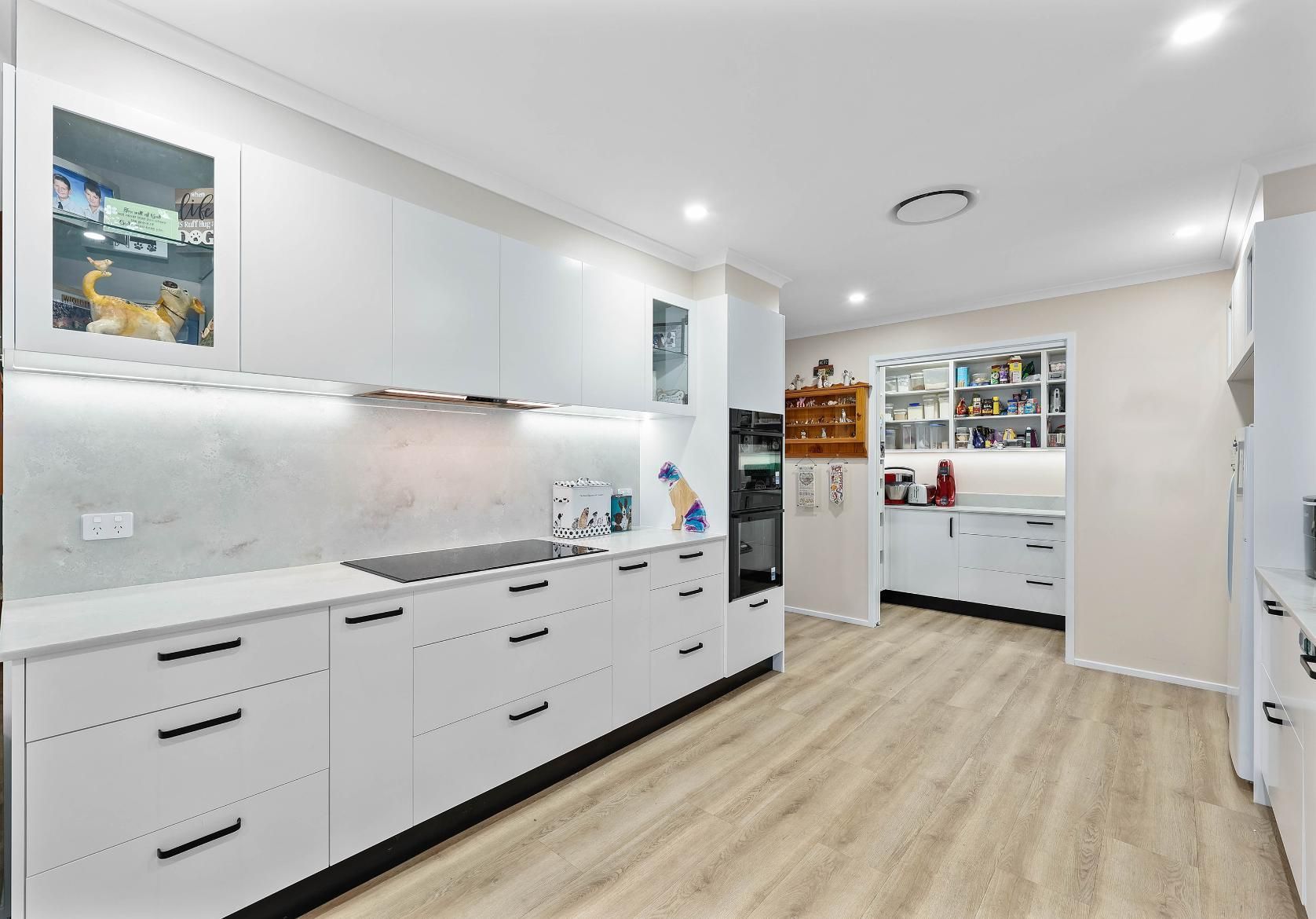Modern White Kitchen With Long Cabinets — Above & Beyond Interiors in Smeaton Grange, NSW