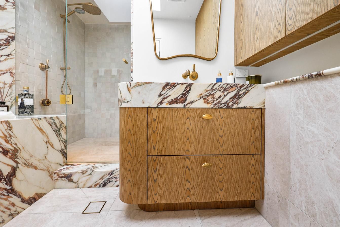 Modern Bathroom With Marble Tile, Wood Vanity — Above & Beyond Interiors in Smeaton Grange, NSW