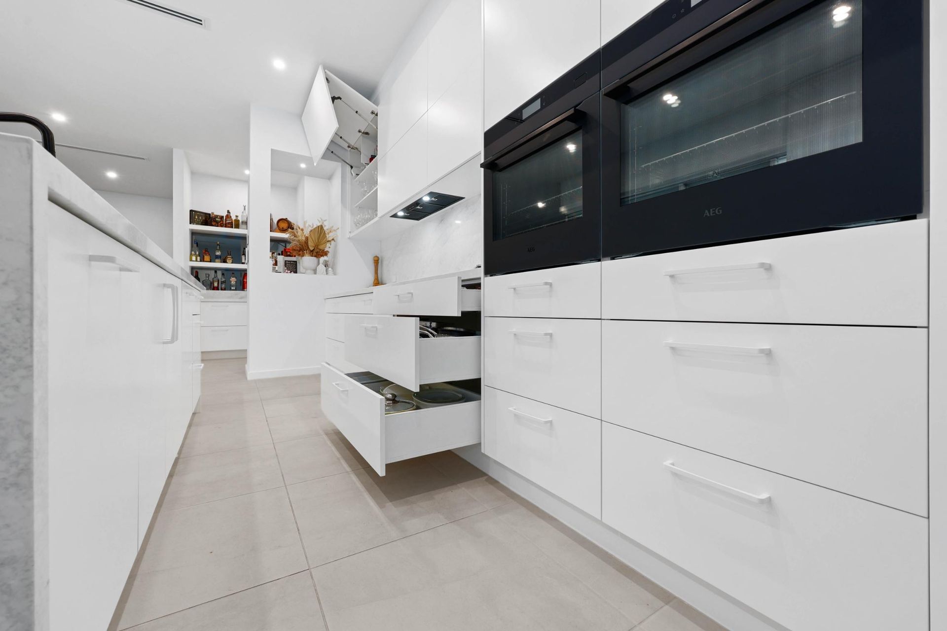 Modern White Kitchen With Built-in Oven — Above & Beyond Interiors in Smeaton Grange, NSW