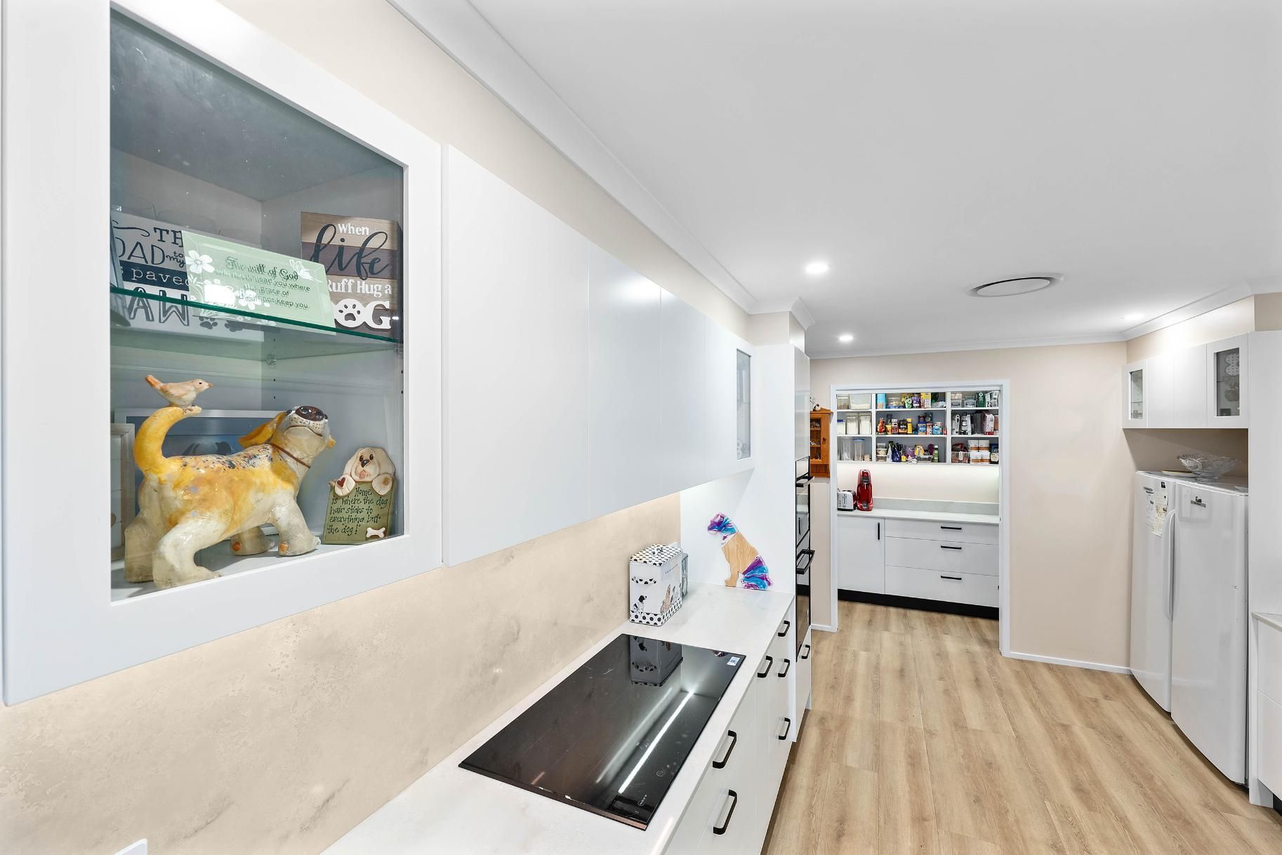 Bright Hallway Laundry Room With White Cabinets — Above & Beyond Interiors in Smeaton Grange, NSW