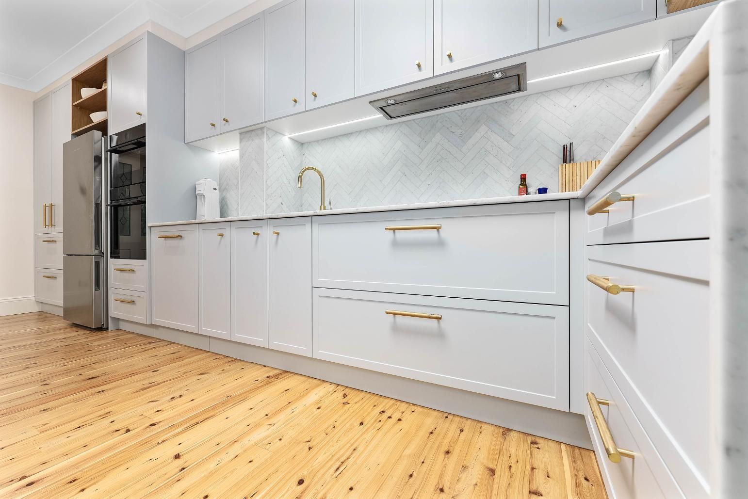 Bright Modern White Kitchen With Cabinets — Above & Beyond Interiors in Smeaton Grange, NSW