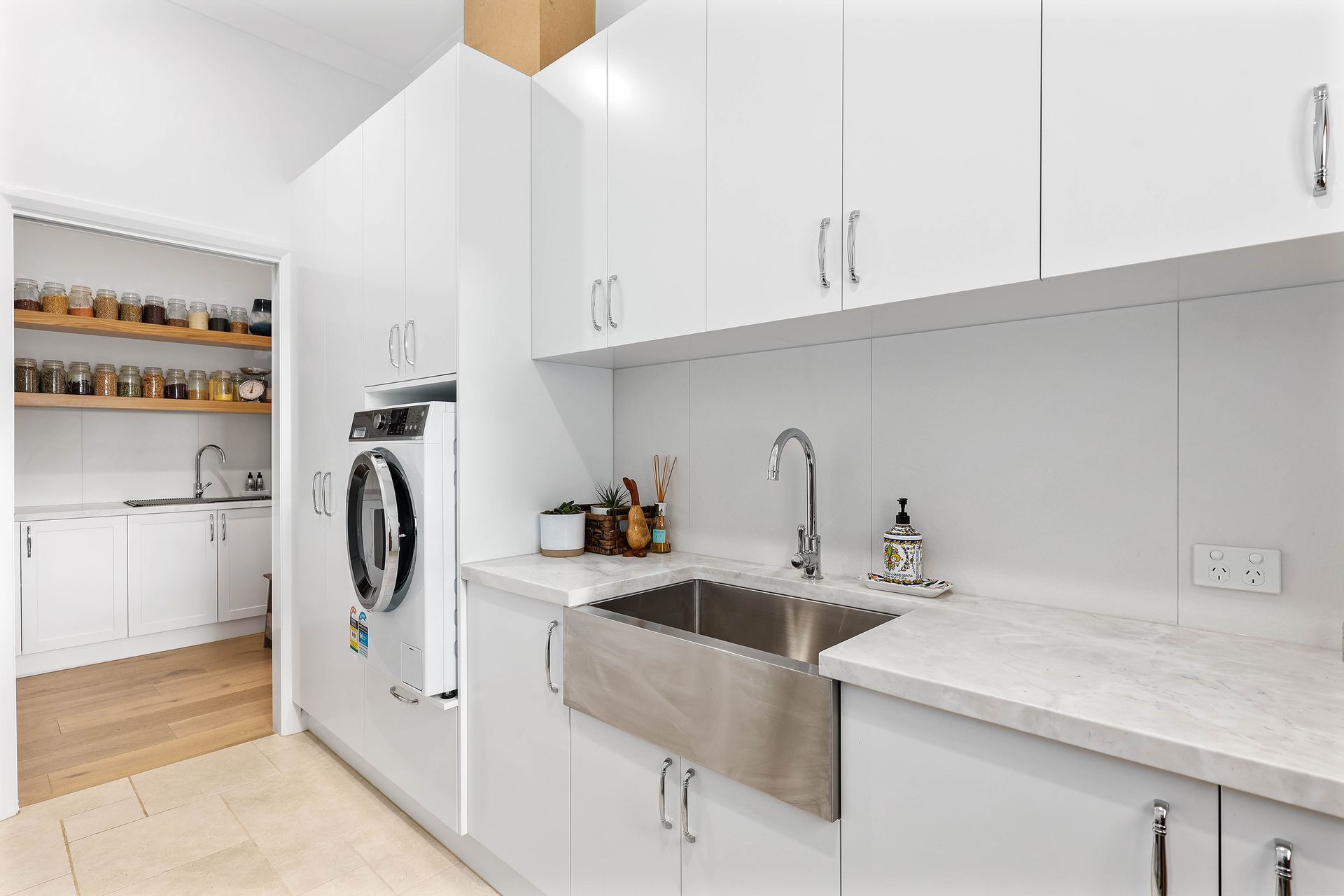 Bright White Laundry Room With Stacked Washer and Dryer — Above & Beyond Interiors in Smeaton Grange, NSW