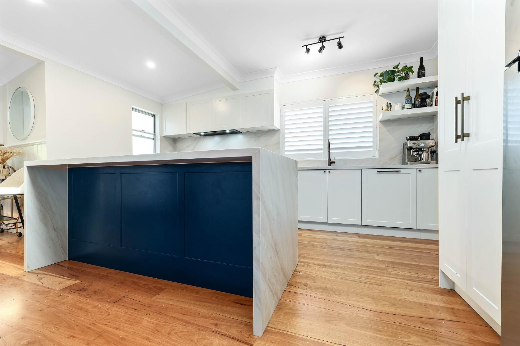 Bright Modern Kitchen With a Dark Blue Island, White Cabinets — Above & Beyond Interiors in Smeaton Grange, NSW
