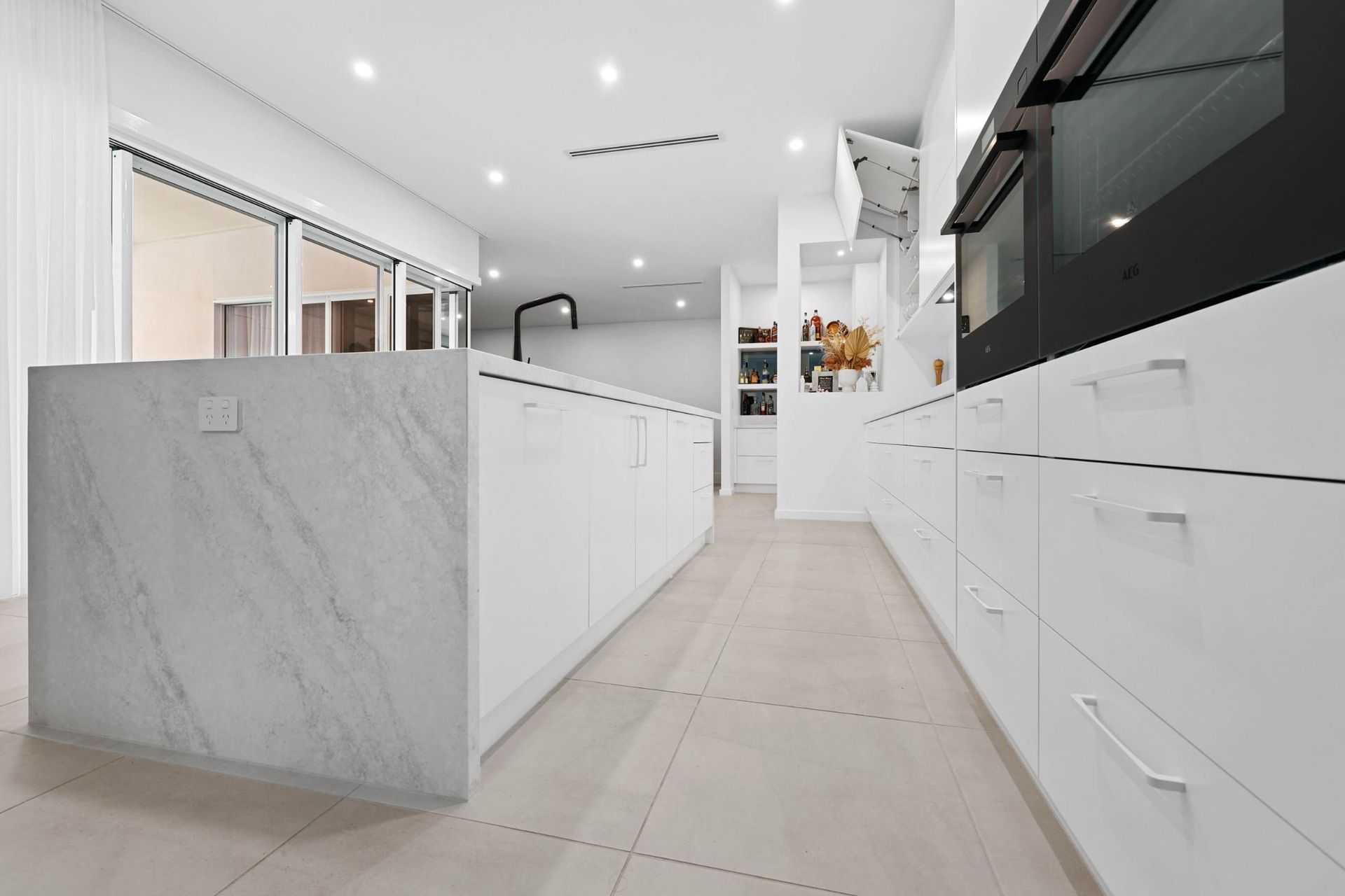 Modern White Kitchen With Marble Island — Above & Beyond Interiors in Smeaton Grange, NSW