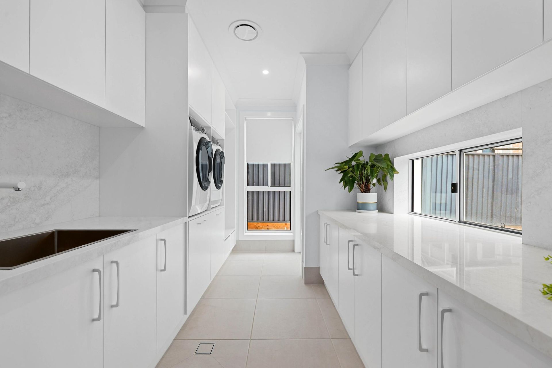 Bright White Galley Kitchen With Long Counters — Above & Beyond Interiors in Smeaton Grange, NSW