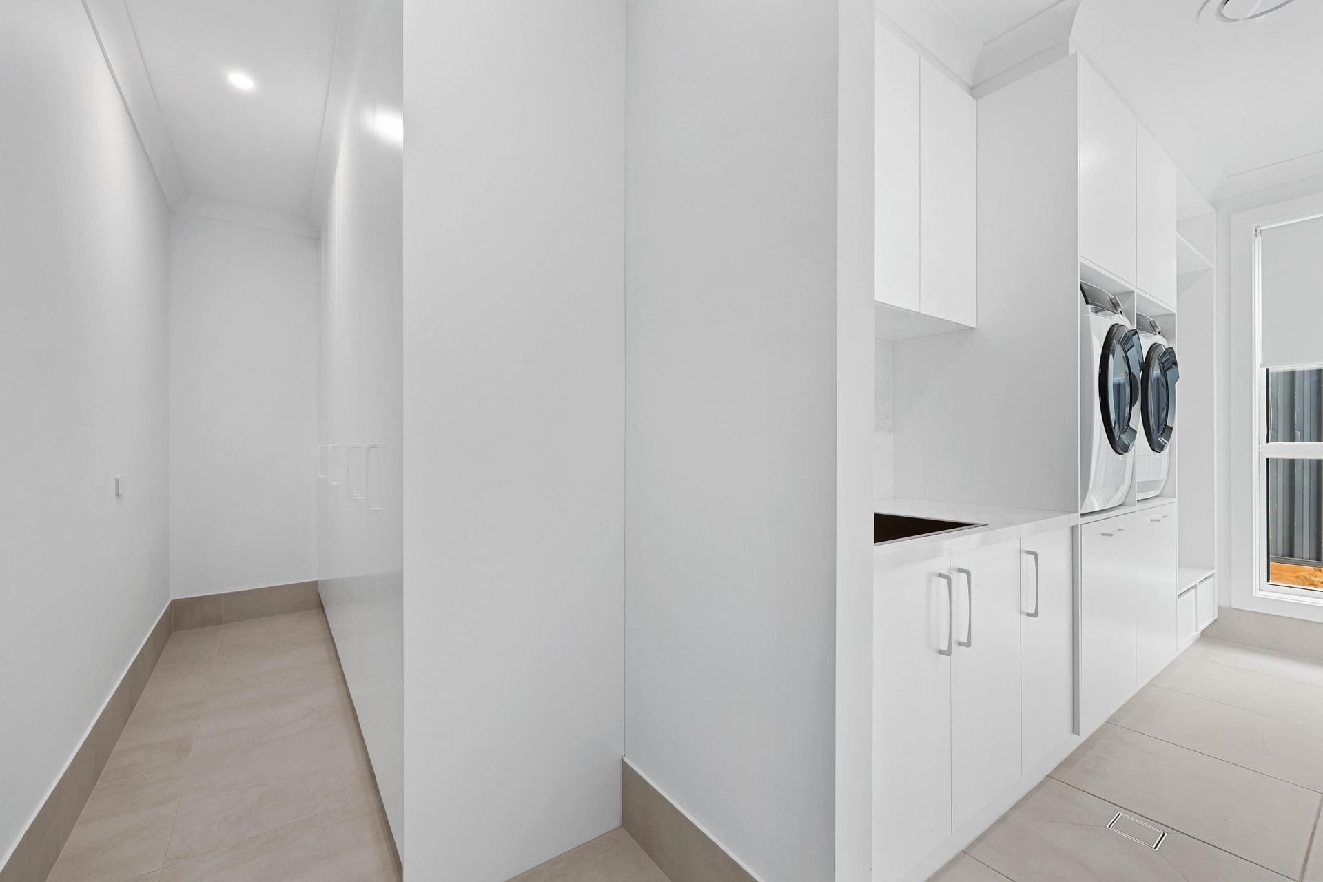 Bright White Hallway and Laundry Room With Cabinets — Above & Beyond Interiors in Smeaton Grange, NSW