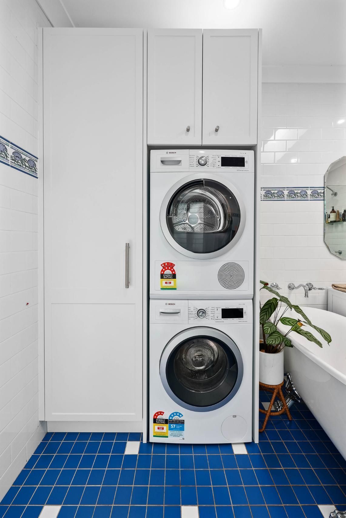 Stacked Washer and Dryer in a Bright Bathroom — Above & Beyond Interiors in Smeaton Grange, NSW