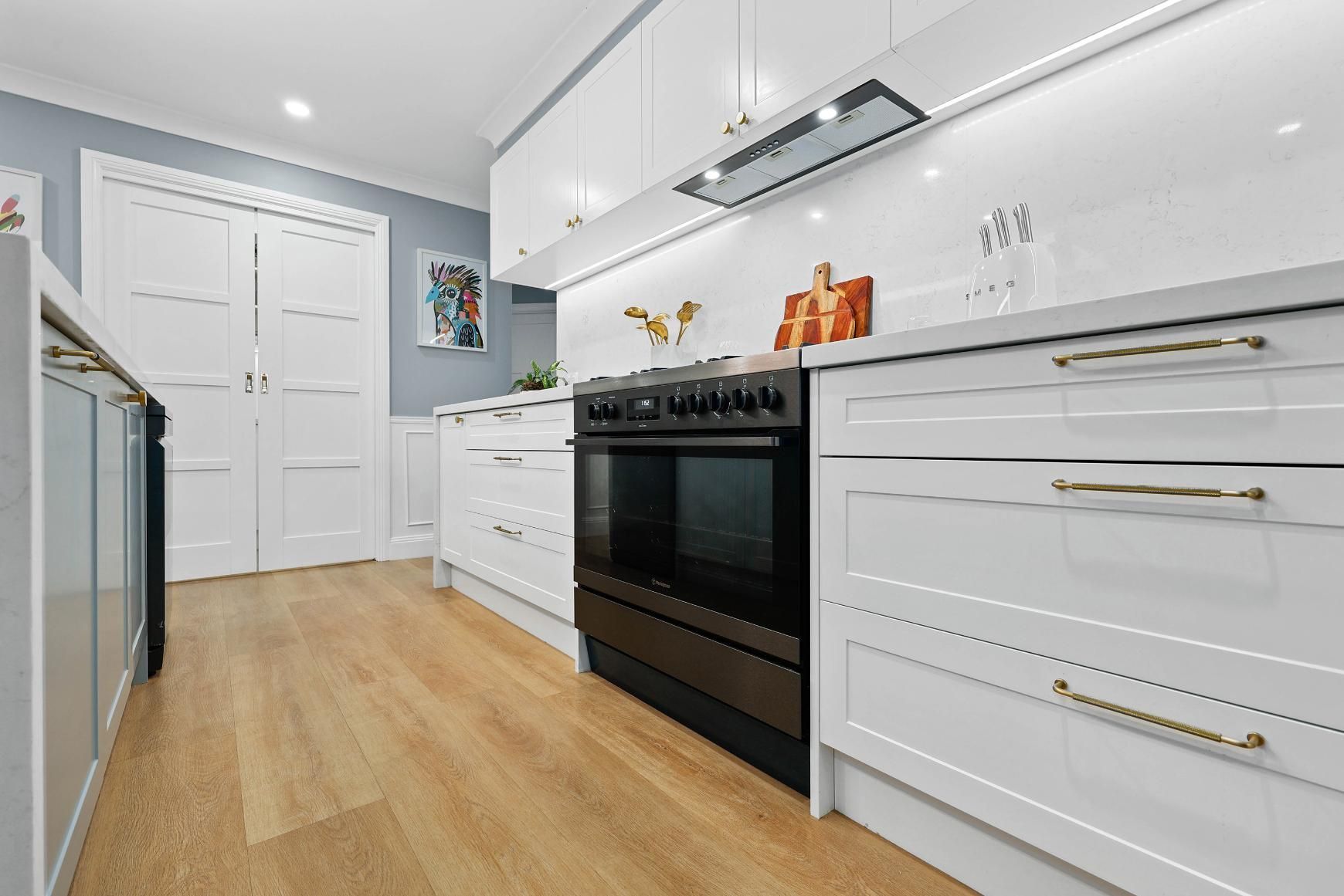 Bright White Modern Kitchen With Black Oven — Above & Beyond Interiors in Smeaton Grange, NSW