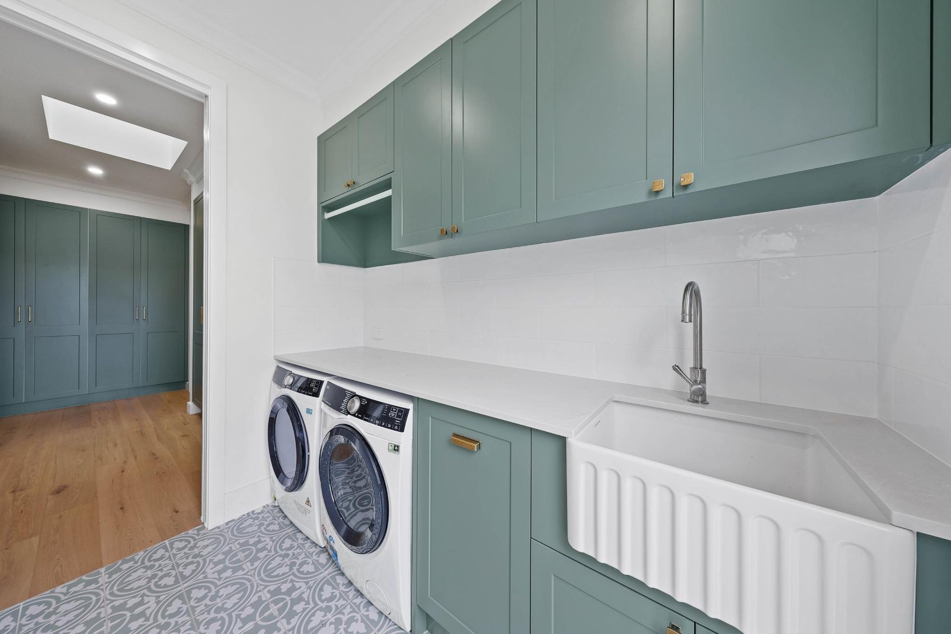 Modern Laundry Room With Teal Cabinets — Above & Beyond Interiors in Smeaton Grange, NSW