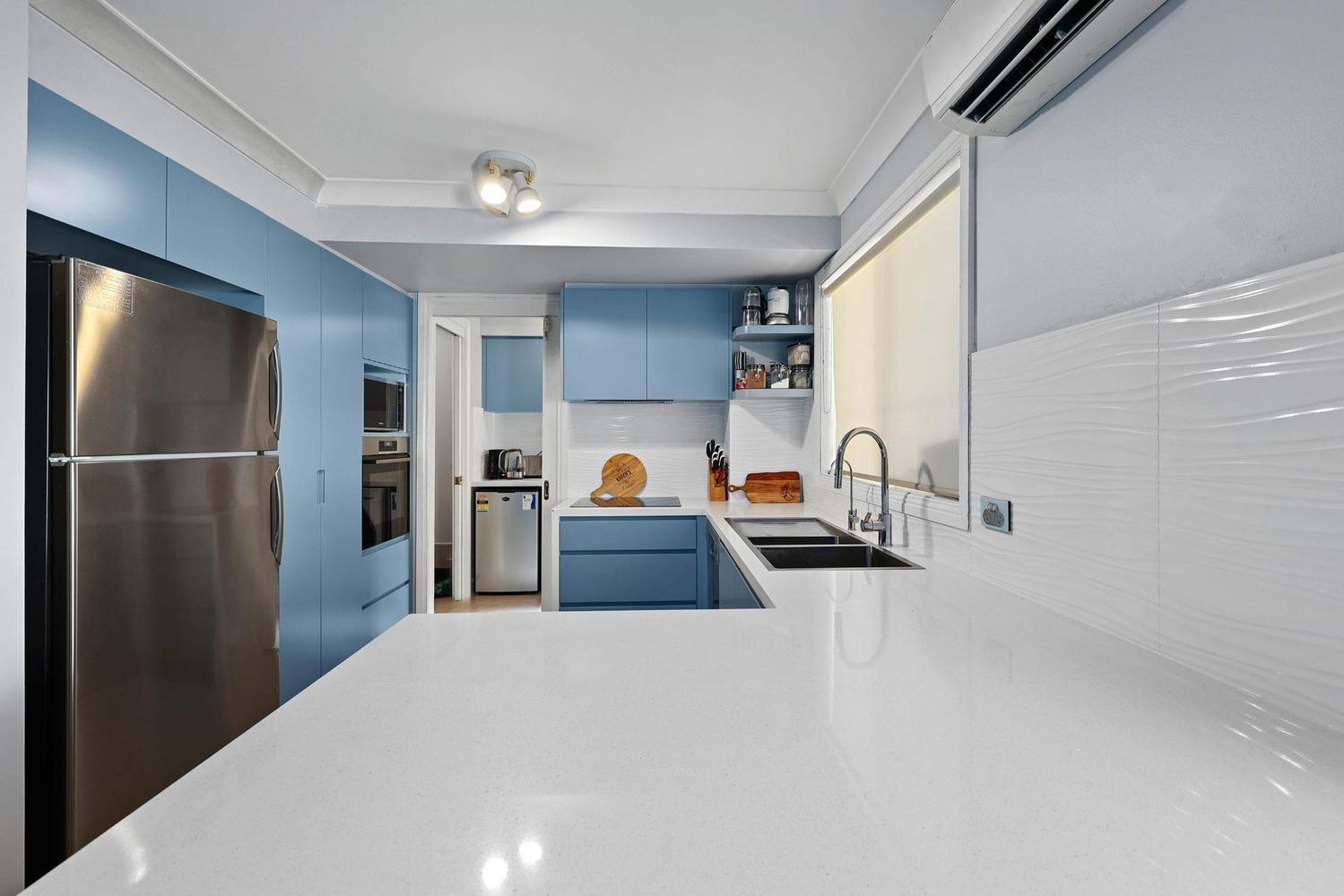 Bright Modern Kitchen With Blue Cabinets — Above & Beyond Interiors in Smeaton Grange, NSW